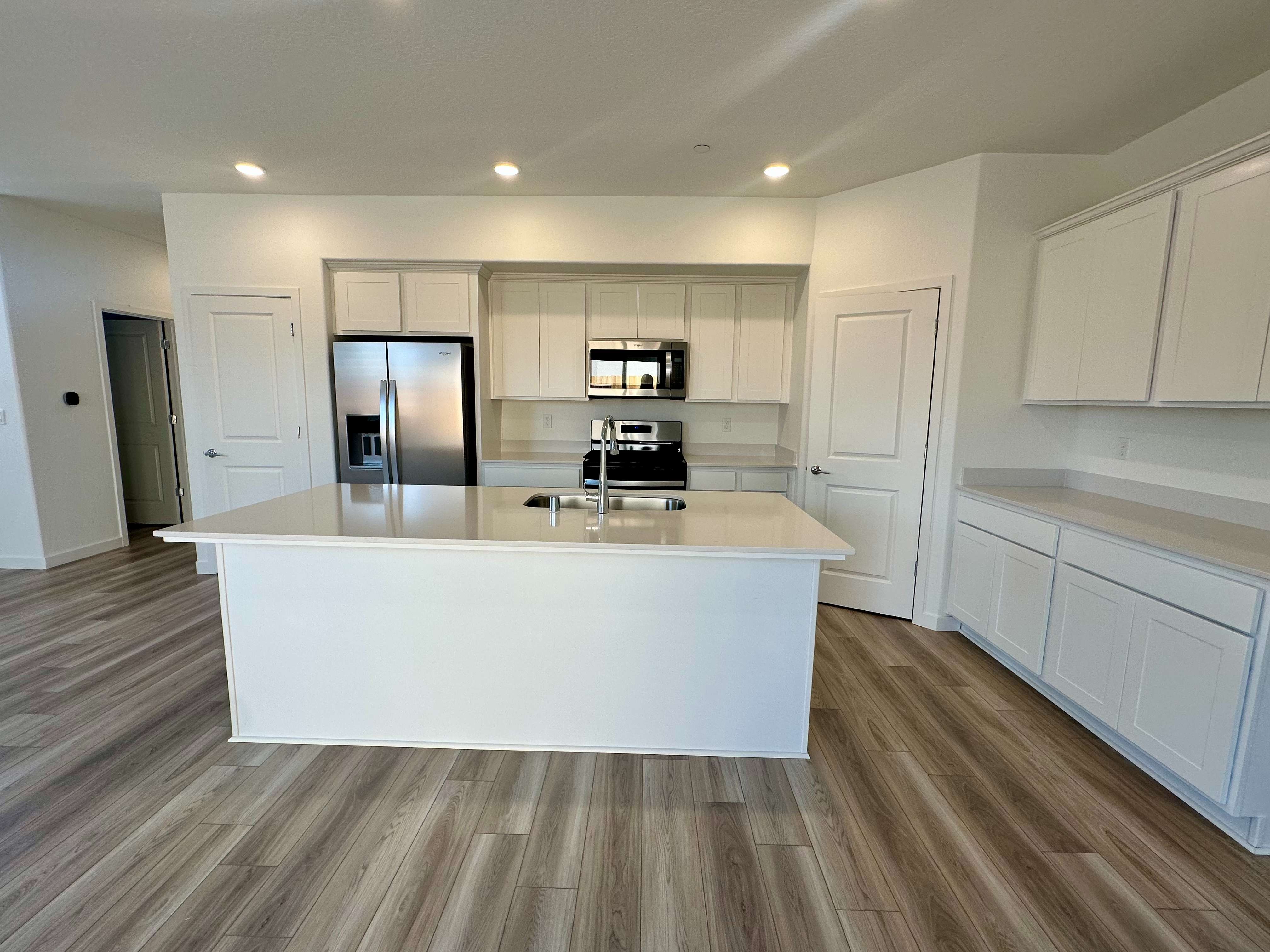 A kitchen with white cabinets.