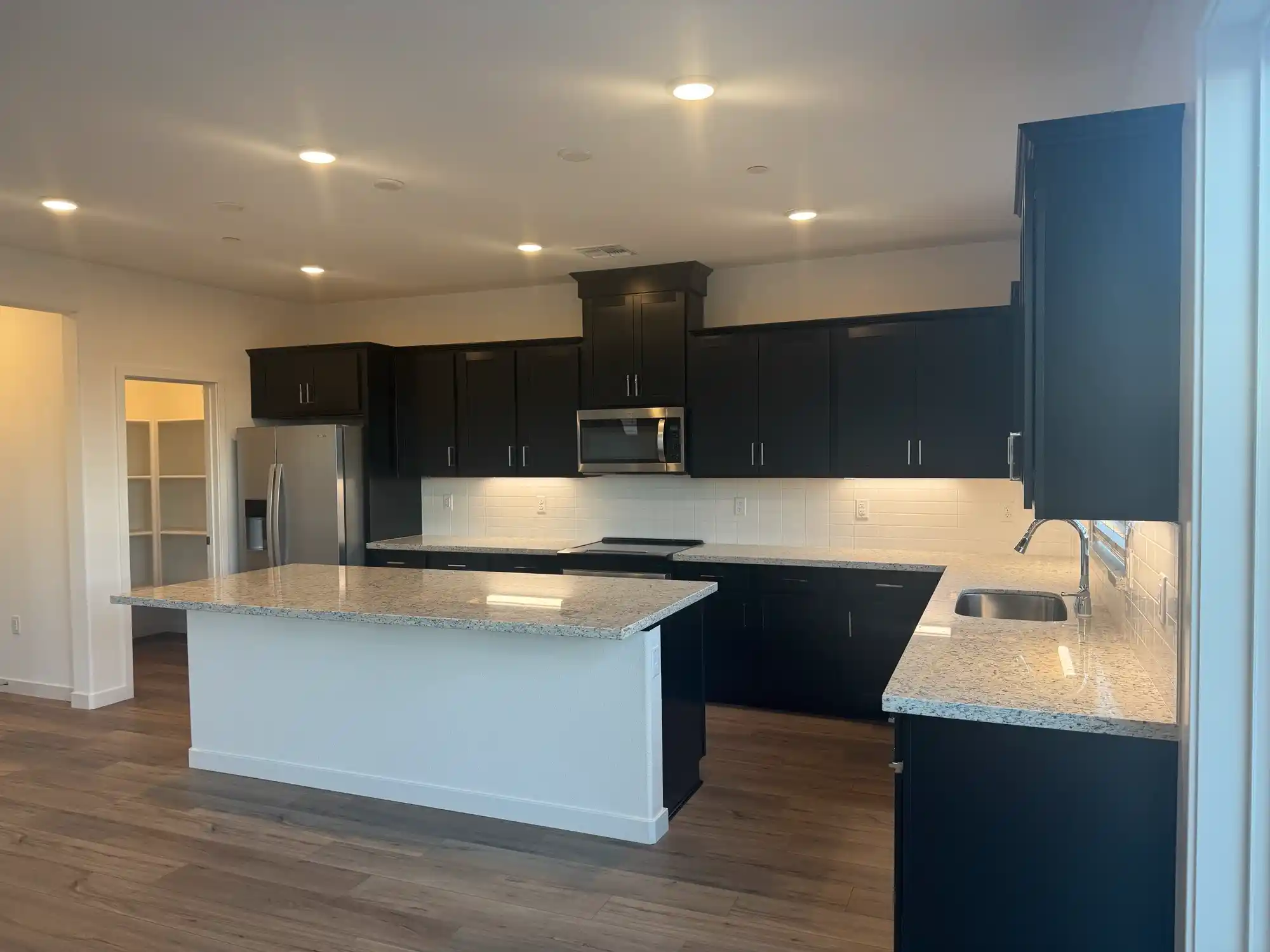 A kitchen with black cabinets.
