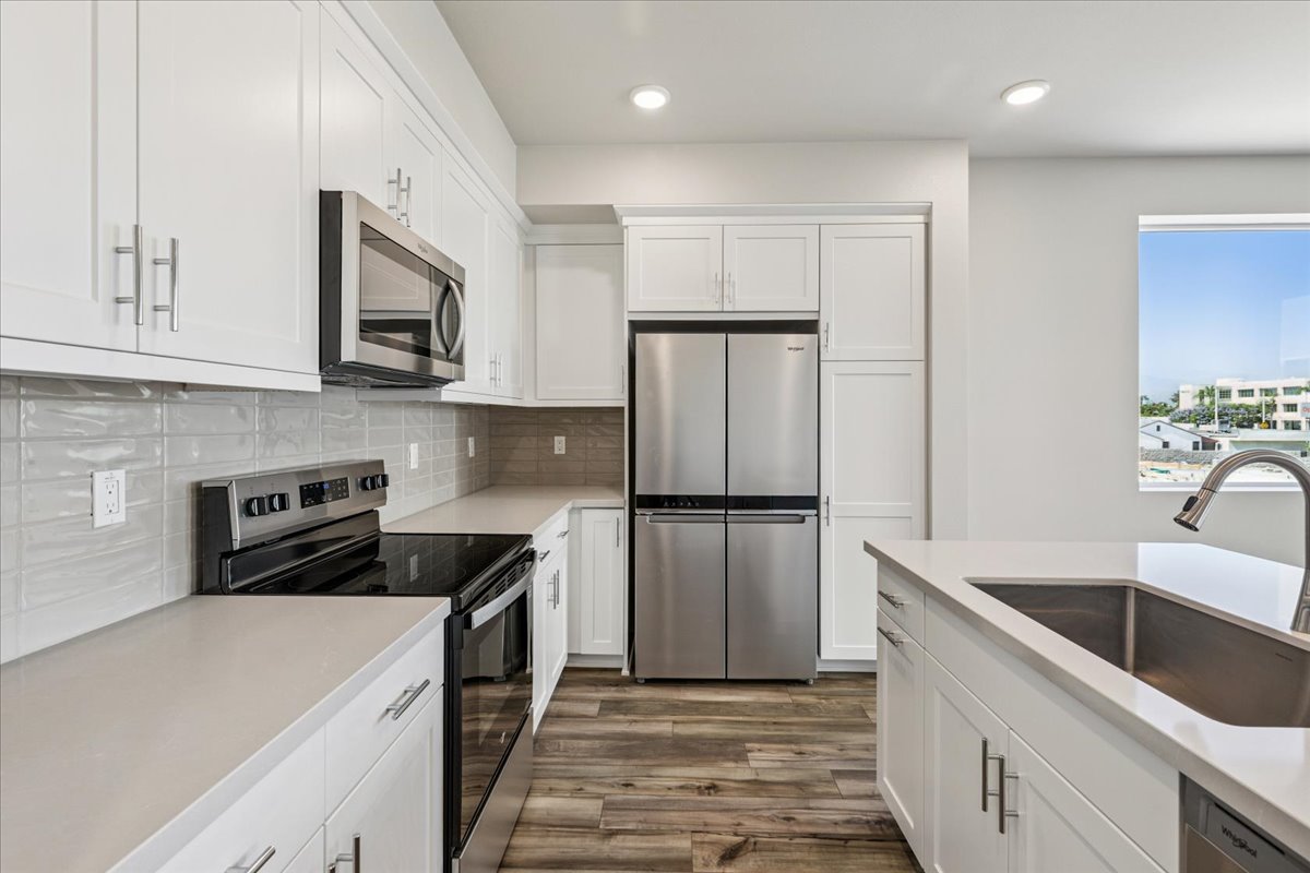 A kitchen with white cabinets.