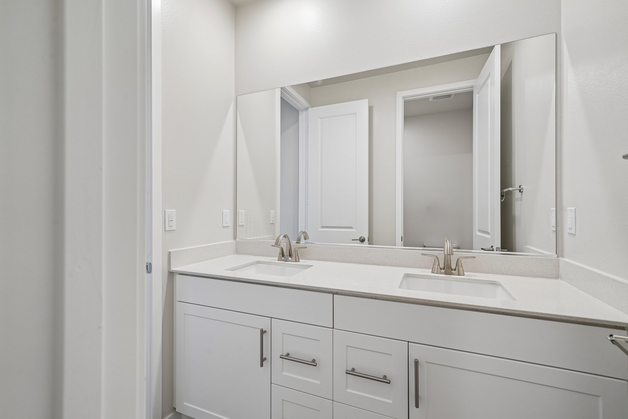A bathroom with a large mirror.