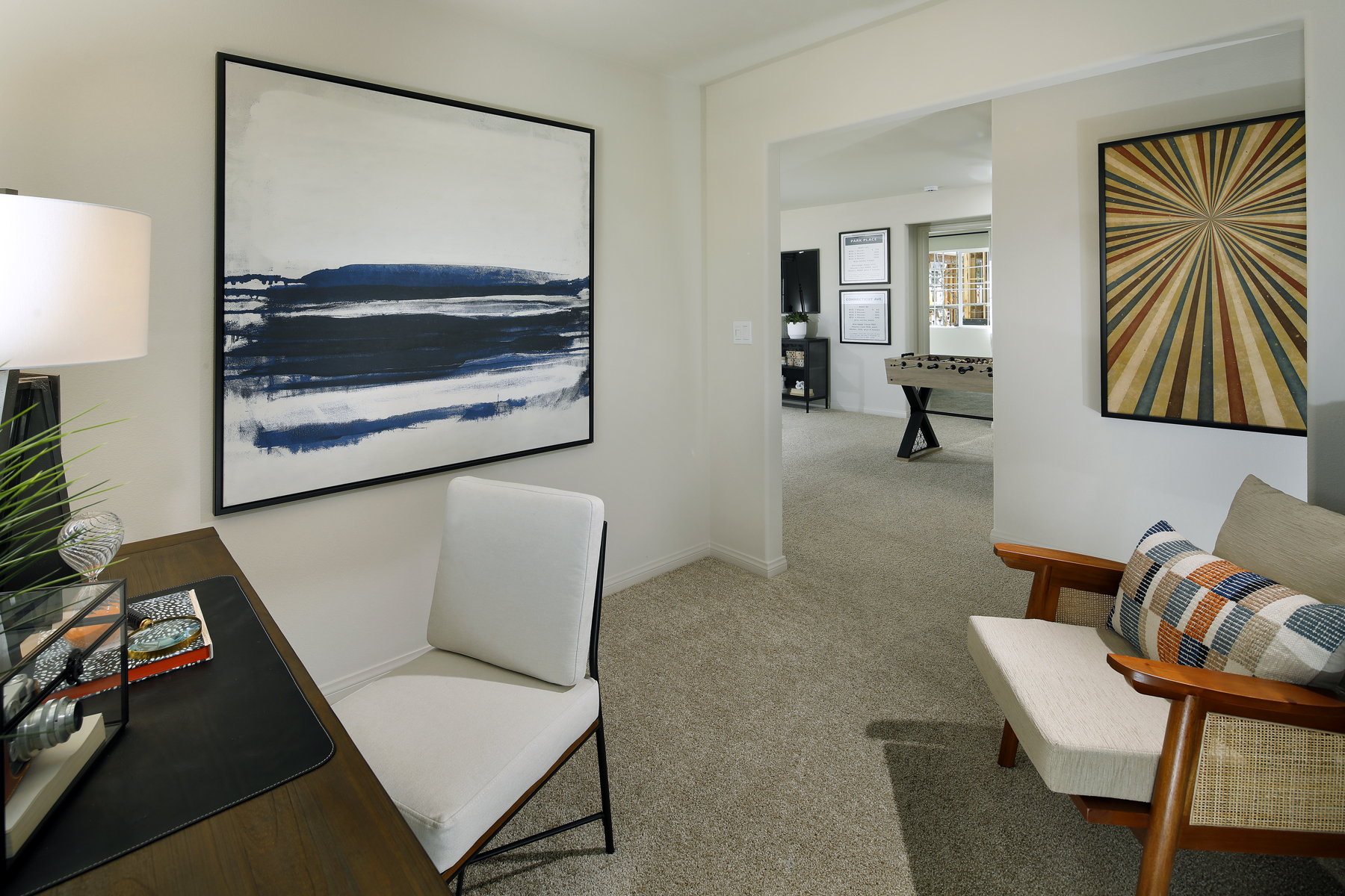 A living room with a piano and a painting on the wall.