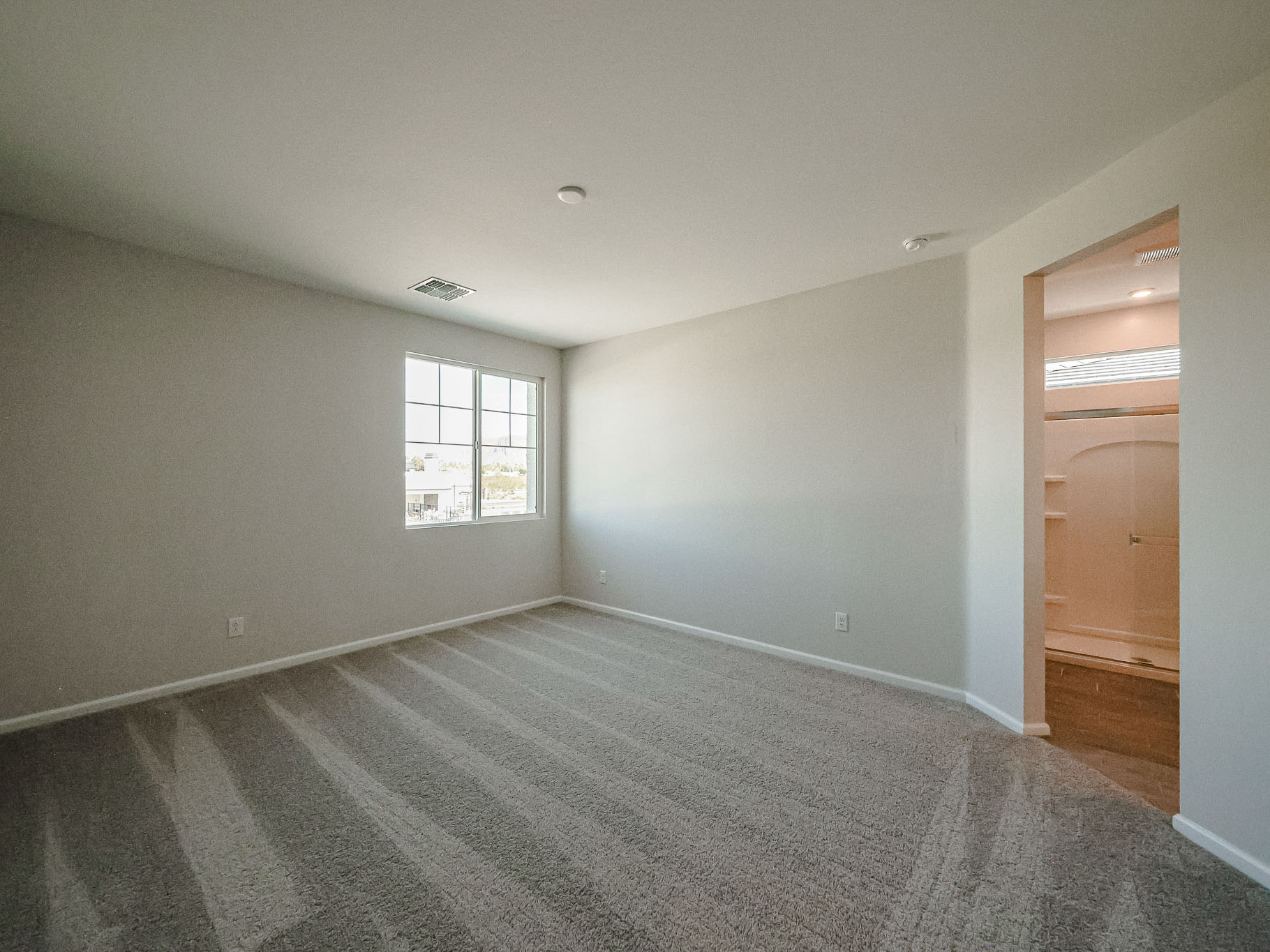 A room with a carpet and a door.