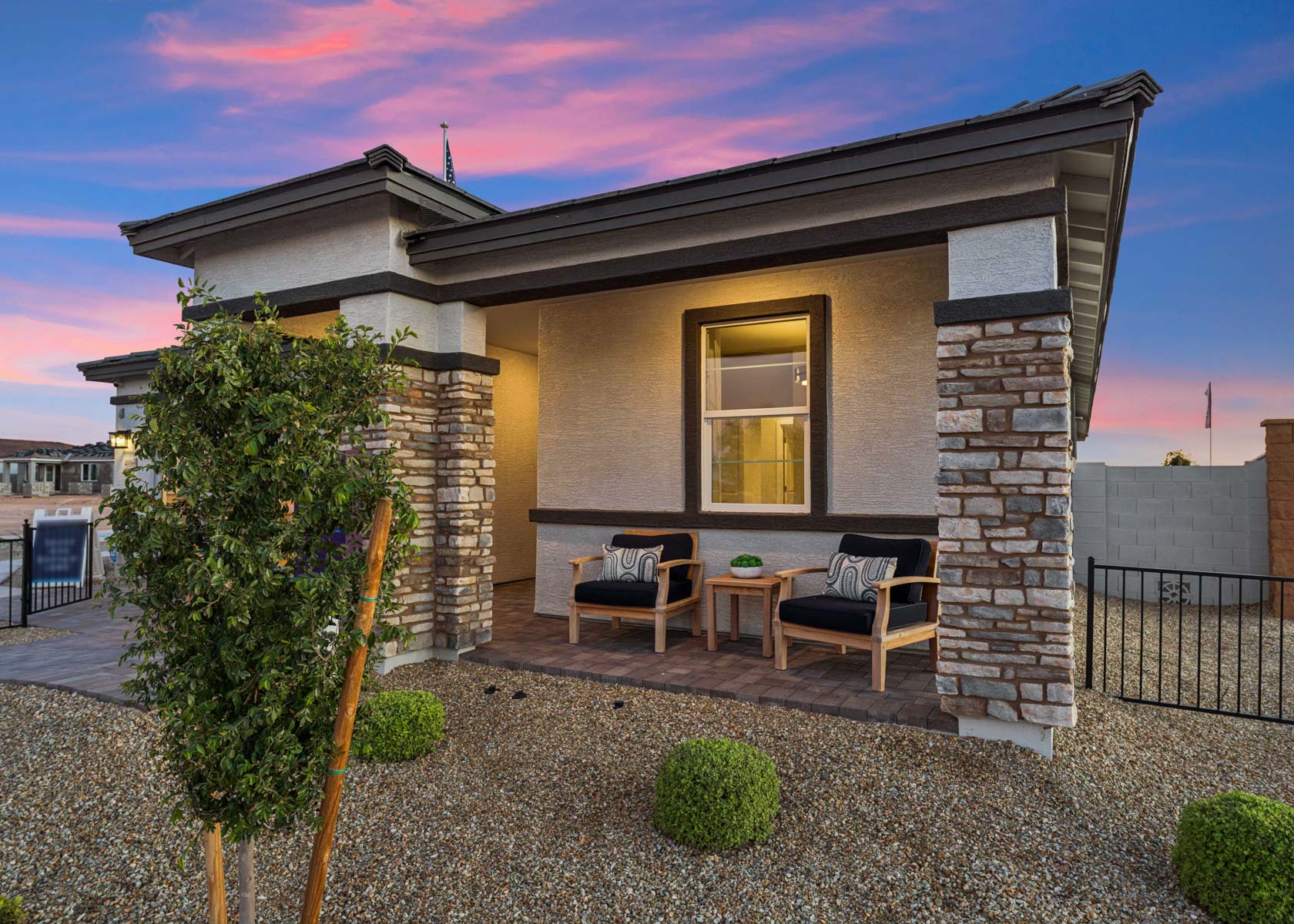 A house with a patio and a table and chairs outside.