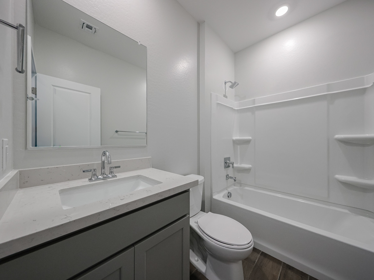 A bathroom with a tub sink and toilet.