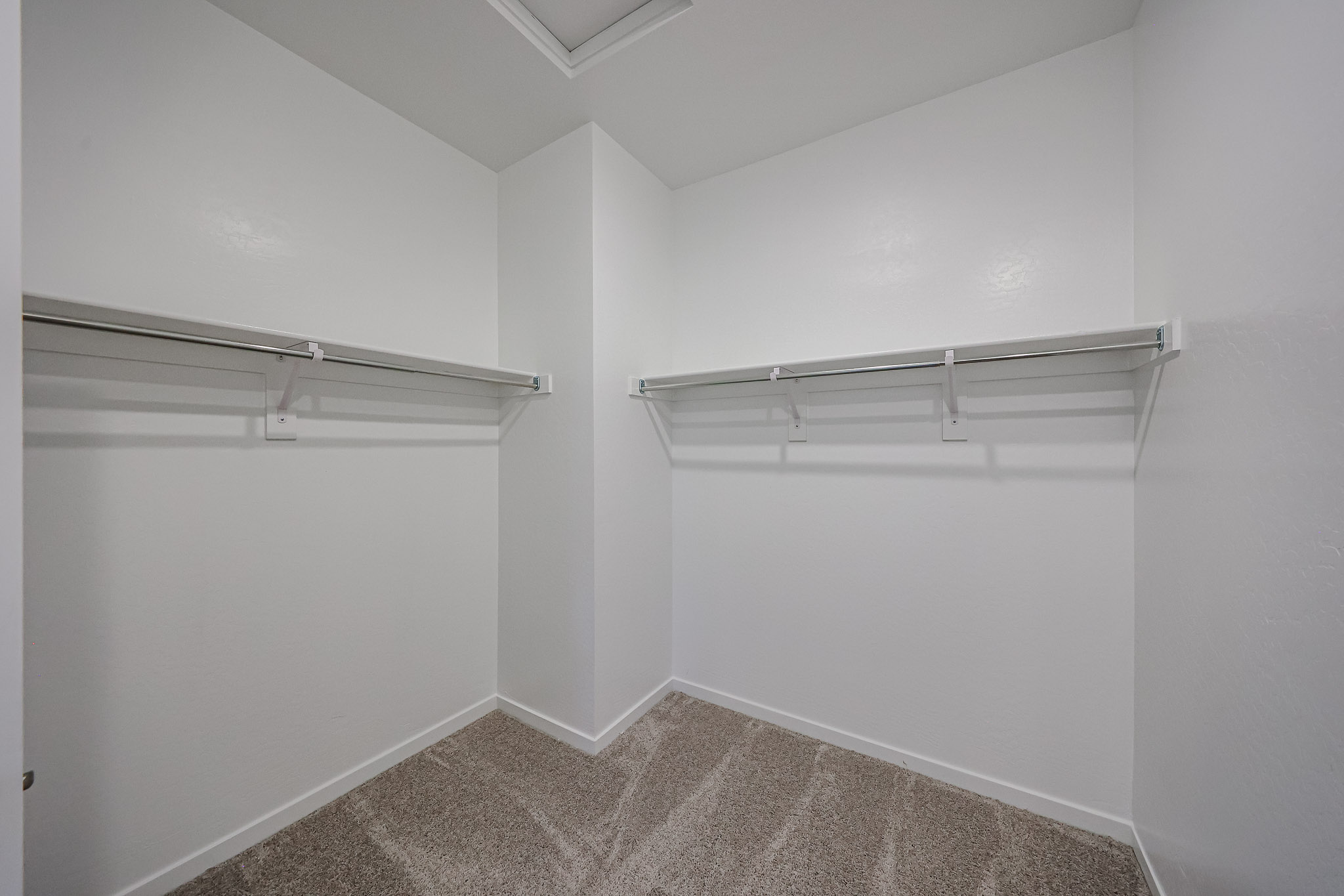 A white room with a shelf.
