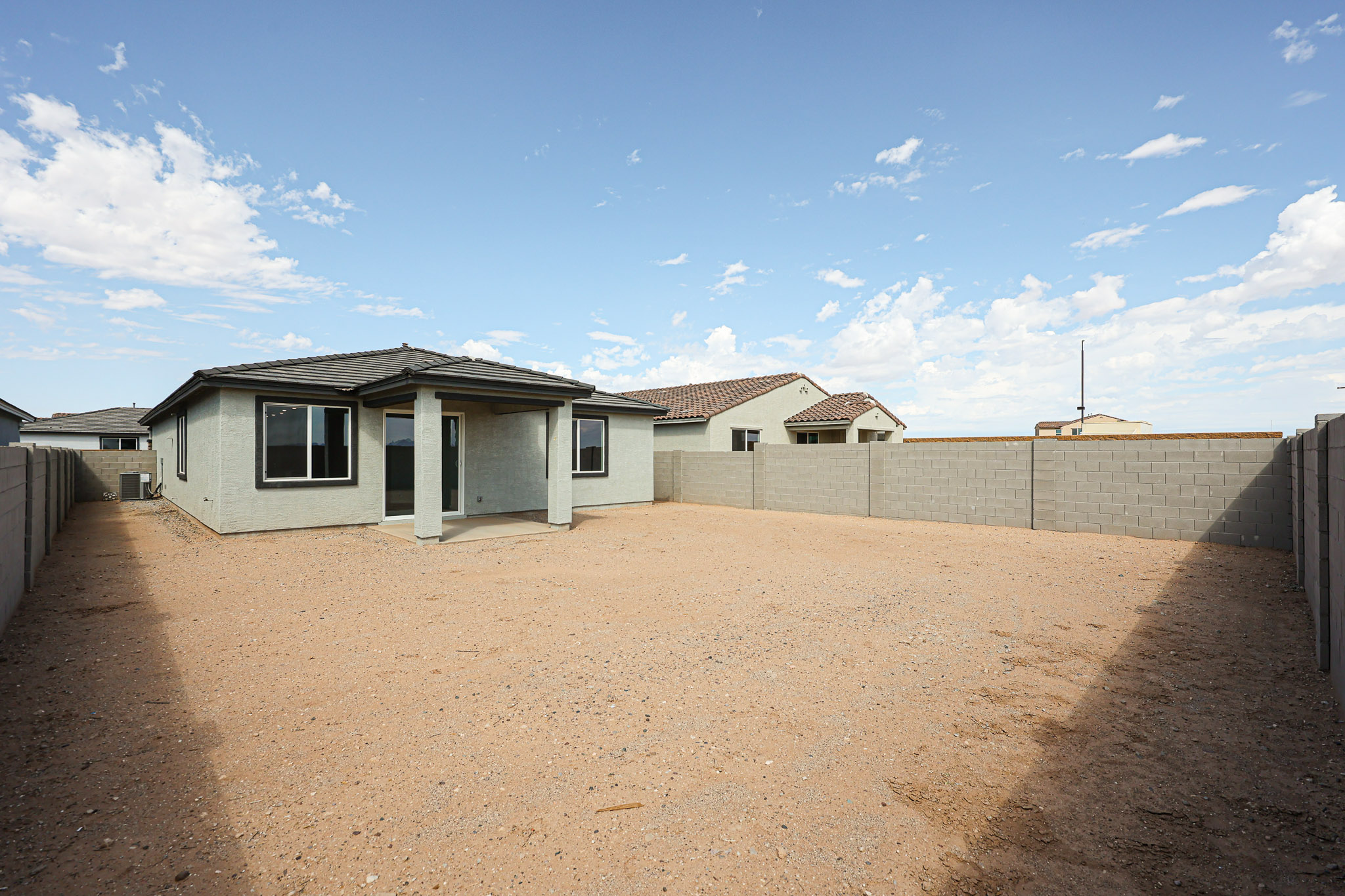 A dirt road leading to a building.
