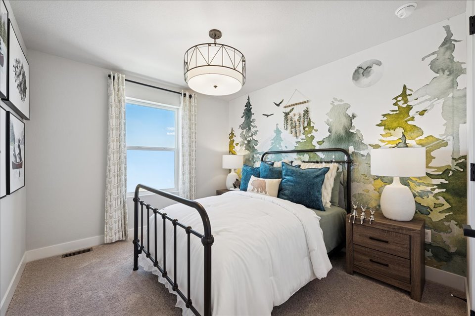 A bedroom with a bed and a lamp.