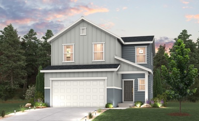 A house with a garage and trees around it.