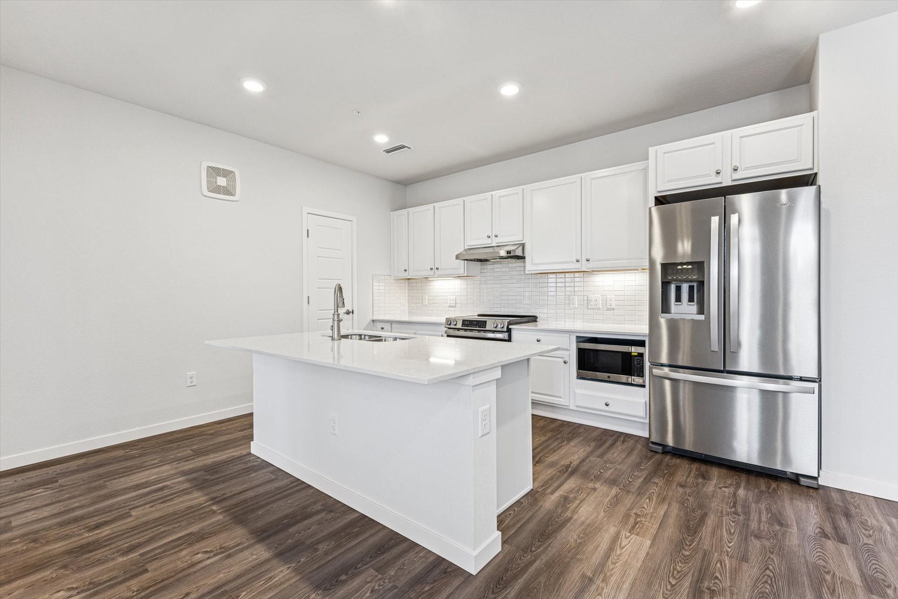 A kitchen with white cabinets.