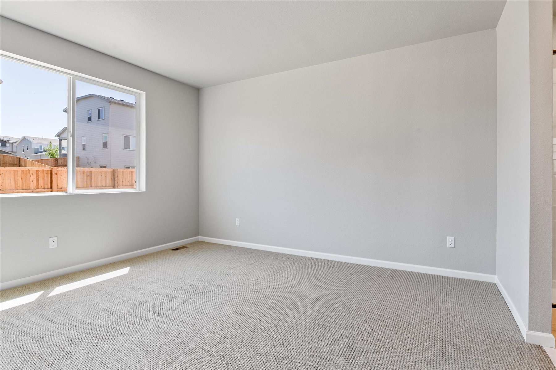 A room with a carpet and a window.