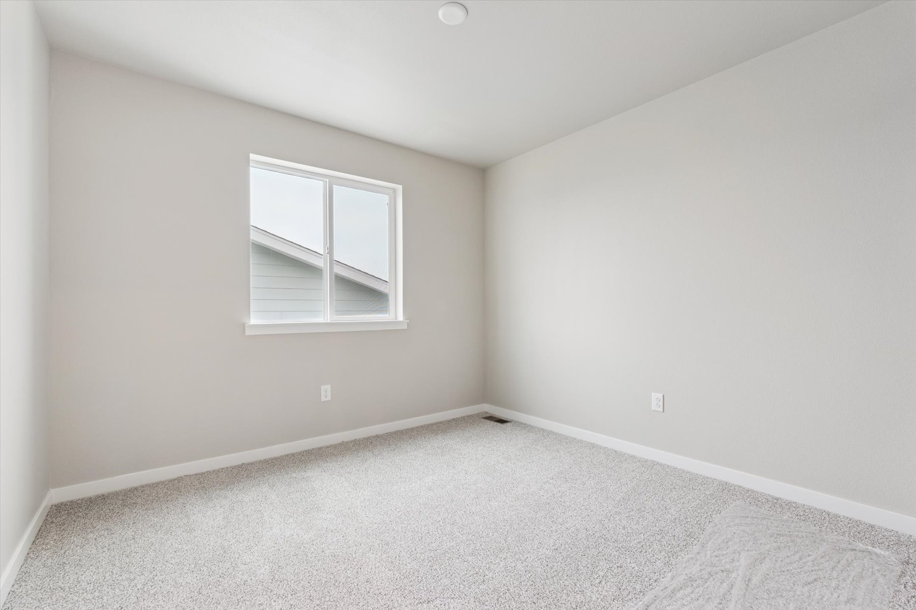 A room with a window and a carpet.