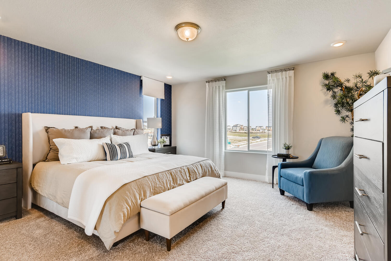 A bedroom with a bed and a chair.