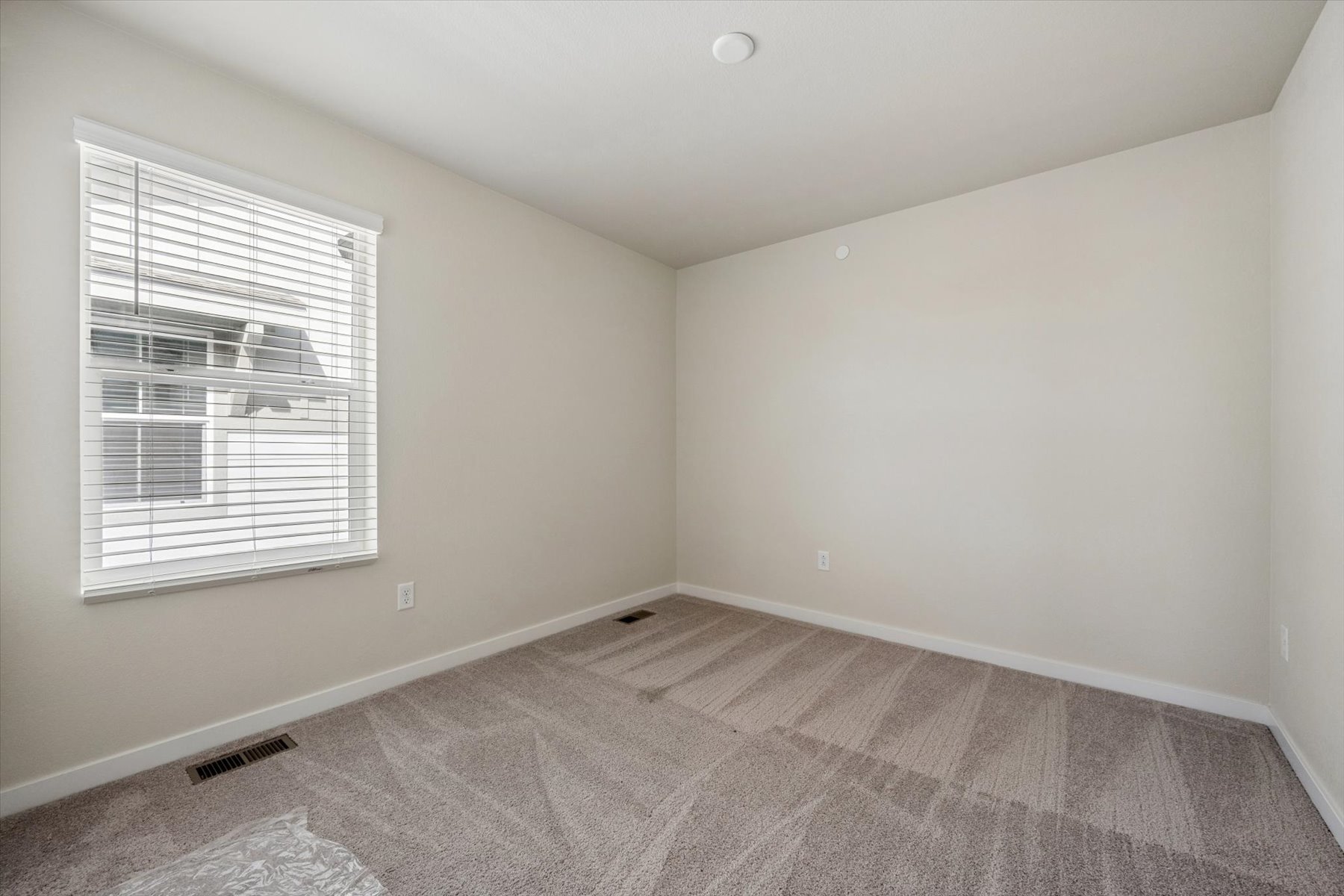 A room with a window and carpet.