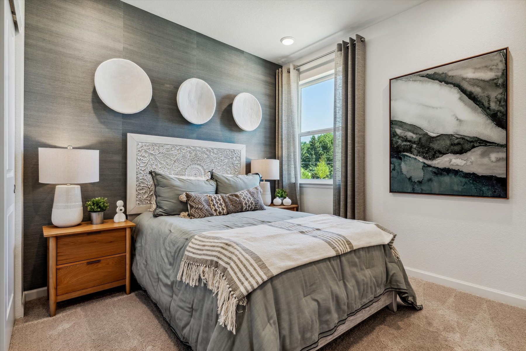 A bedroom with a bed and lamps.