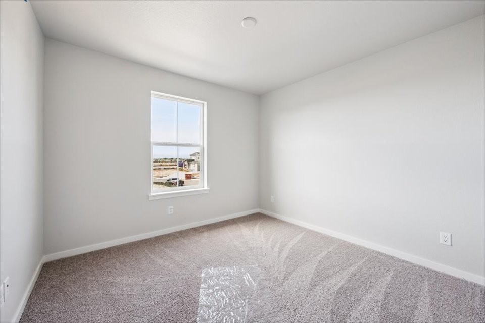 A room with a window and carpet.