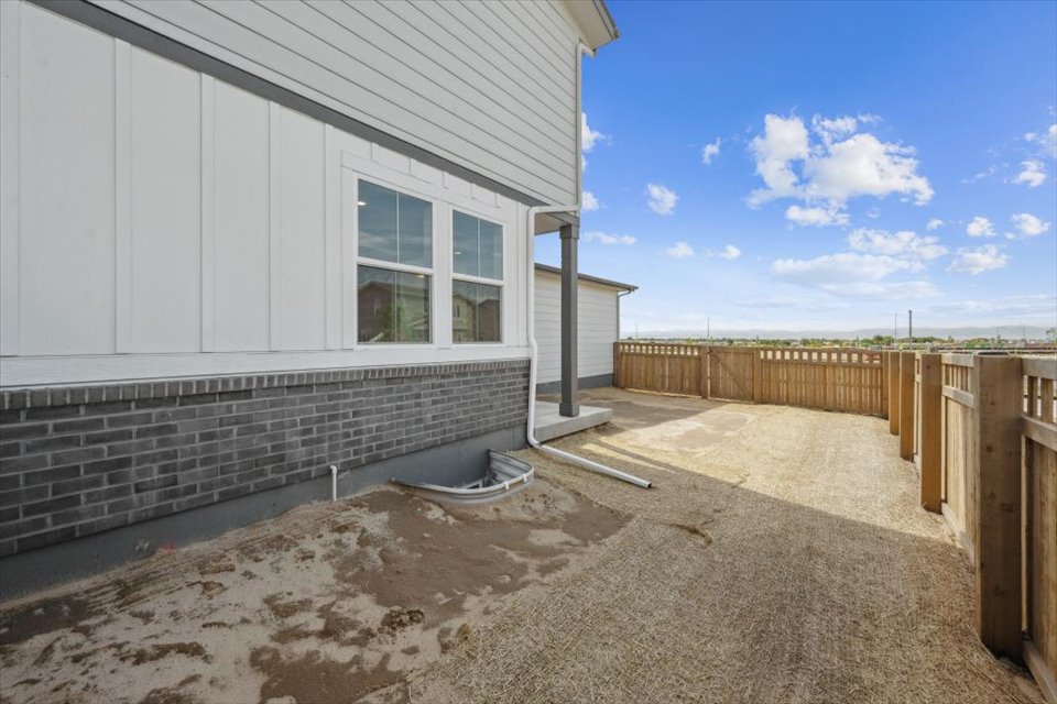 A building with a fence and a dirt yard.
