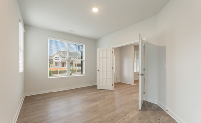 A room with a wood floor and a window.