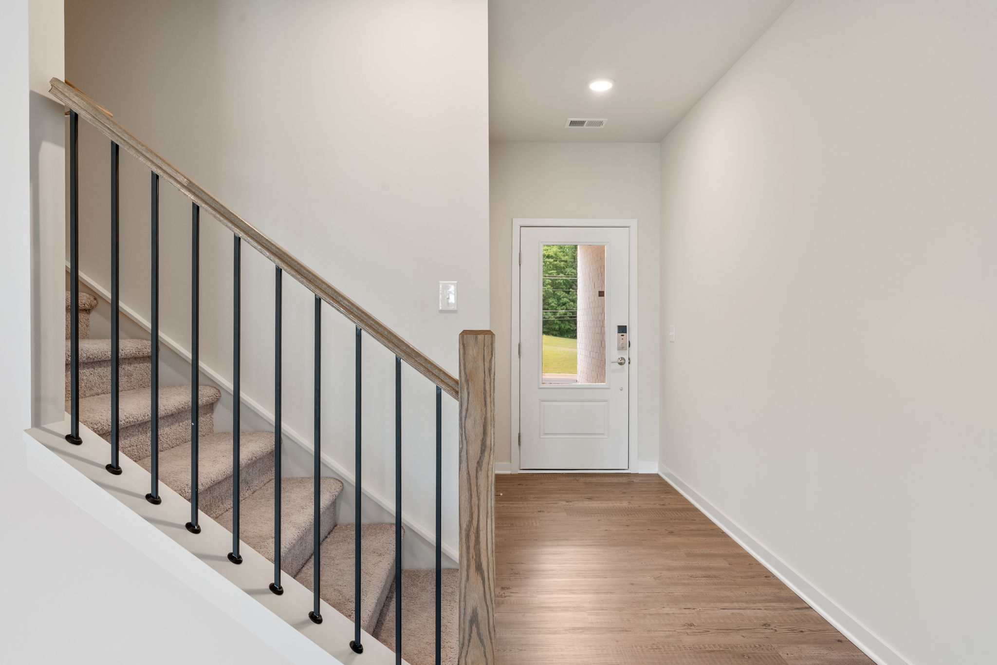 A white hallway with a glass door.