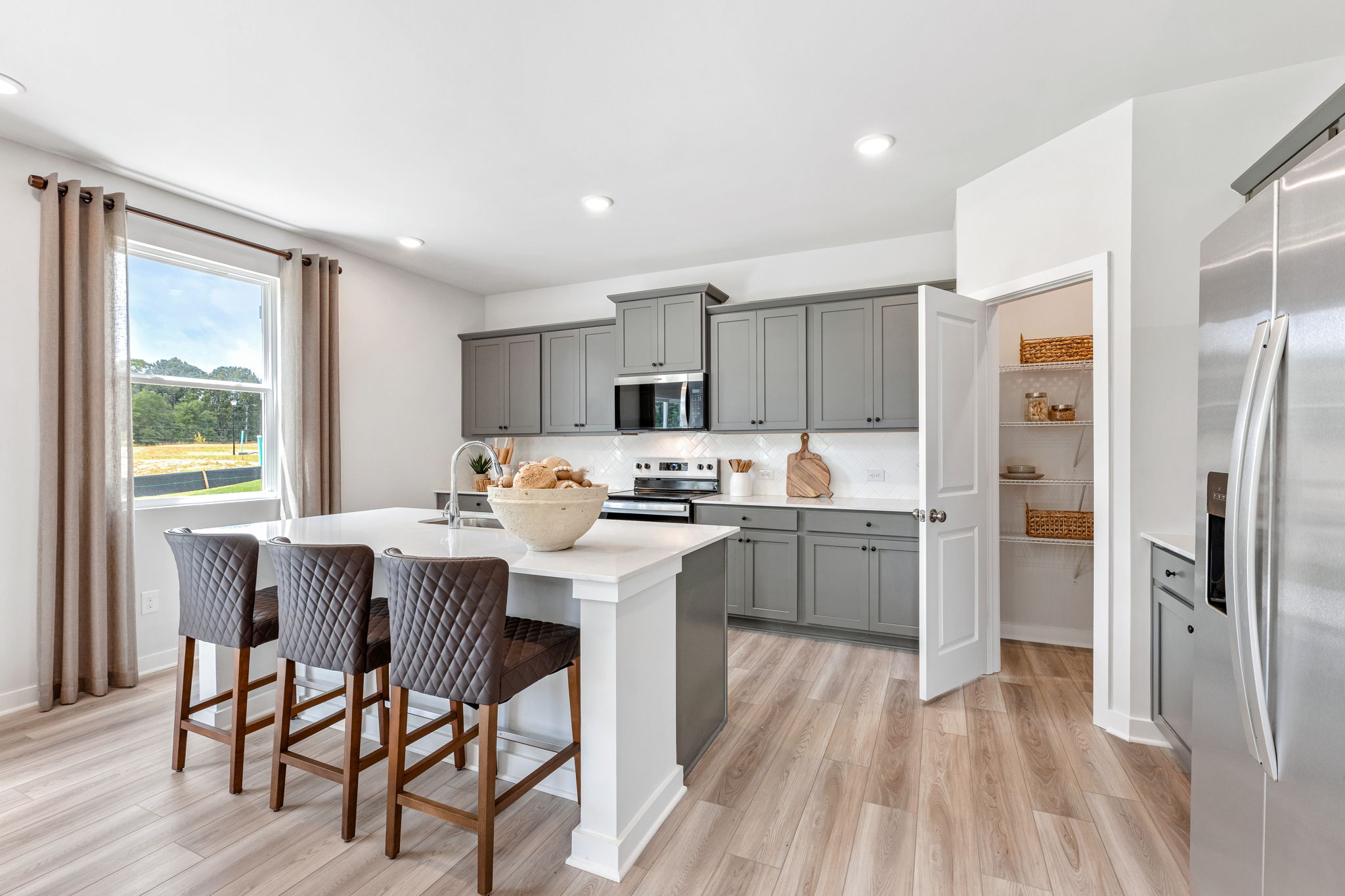 A kitchen with a dining table and a large window.
