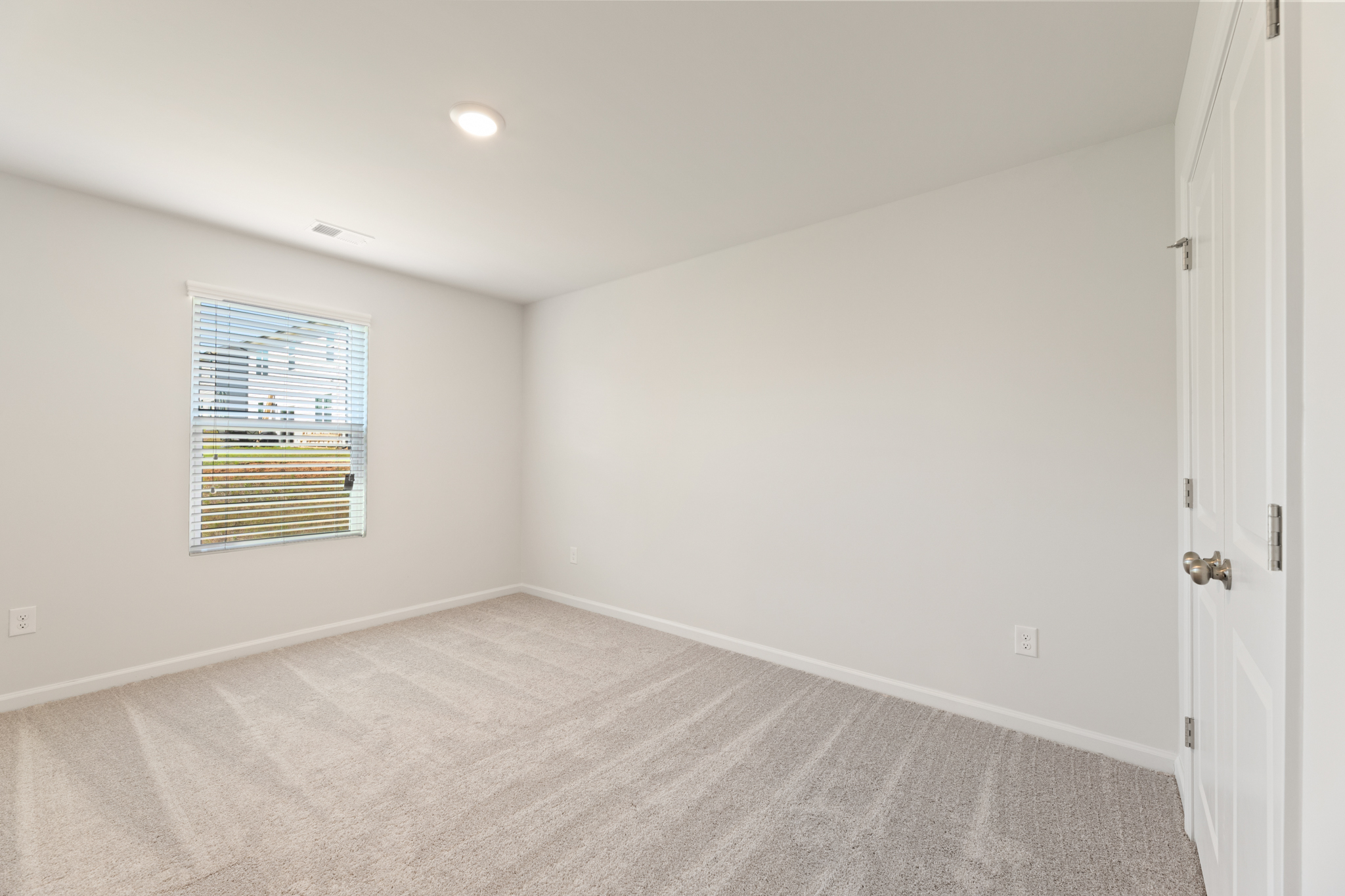 A room with a carpet and a window.