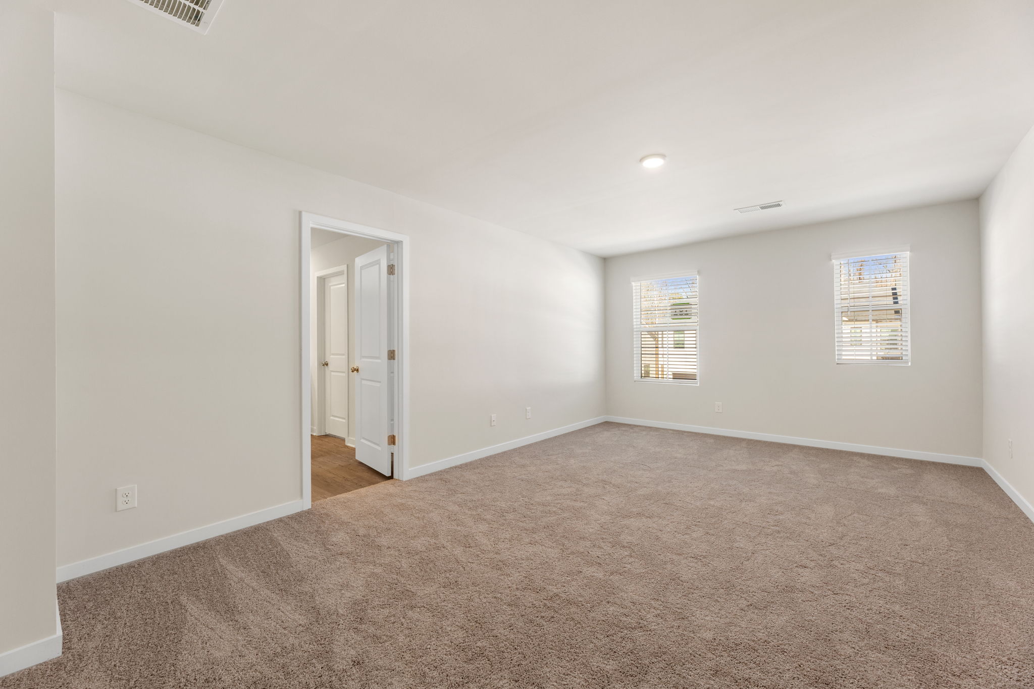 A hallway with carpet and a door.