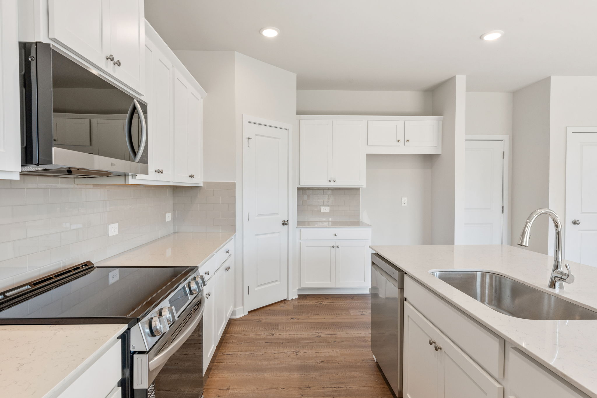 A kitchen with white cabinets.