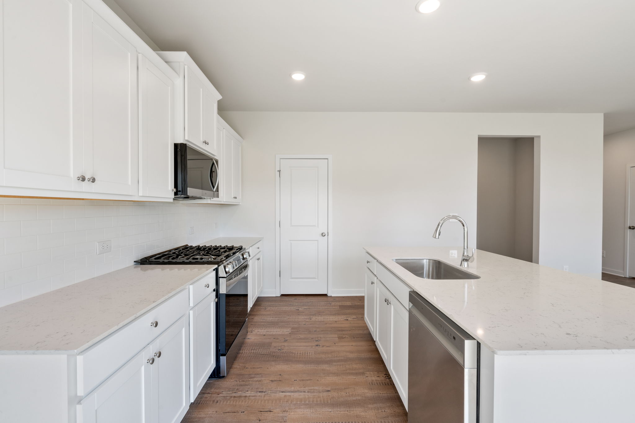 A kitchen with white cabinets.