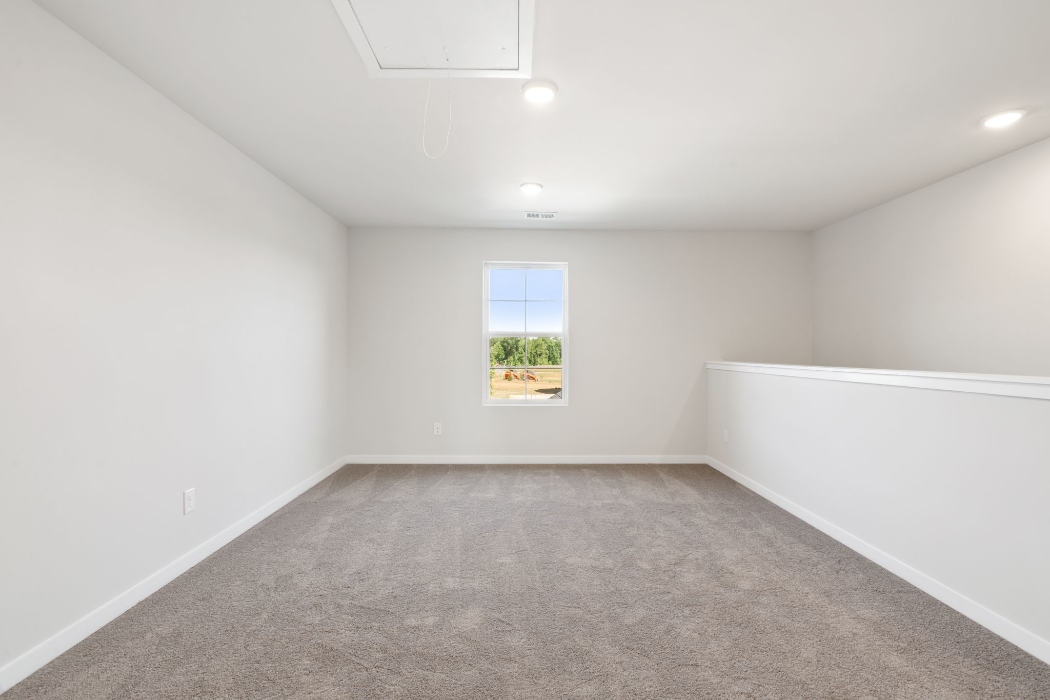 A room with a window and a carpet.