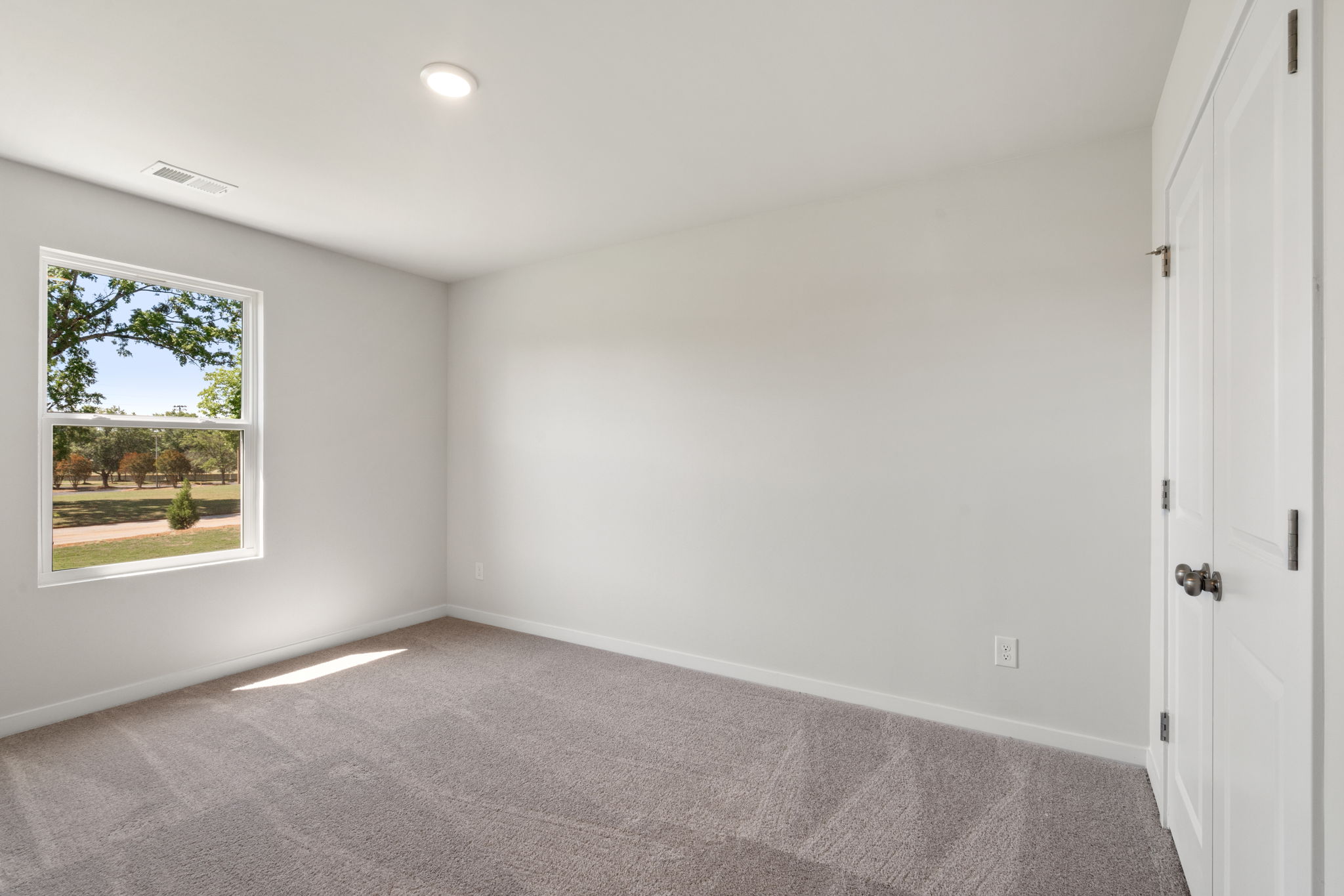 A room with a window and a carpet.