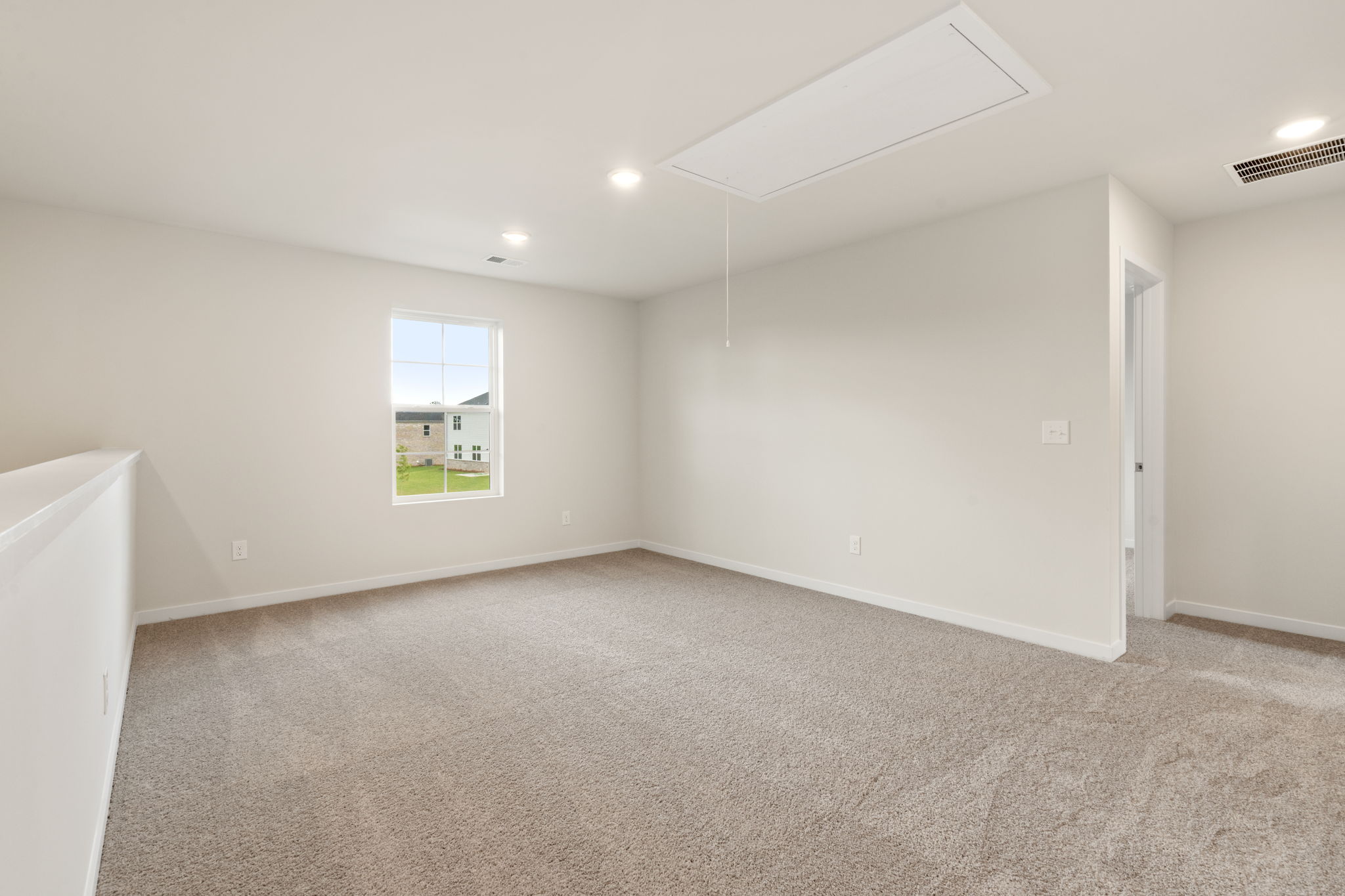 A room with a carpet and a window.