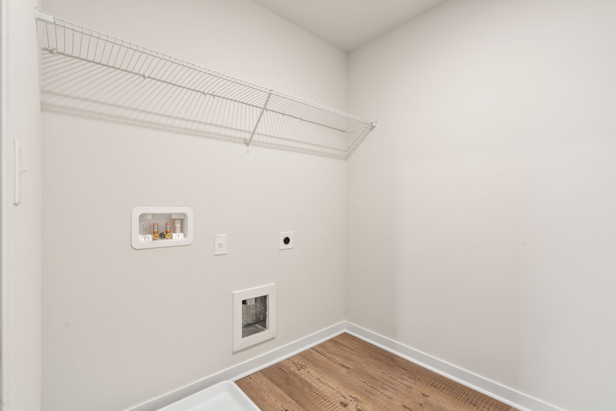 A white room with a wood floor.