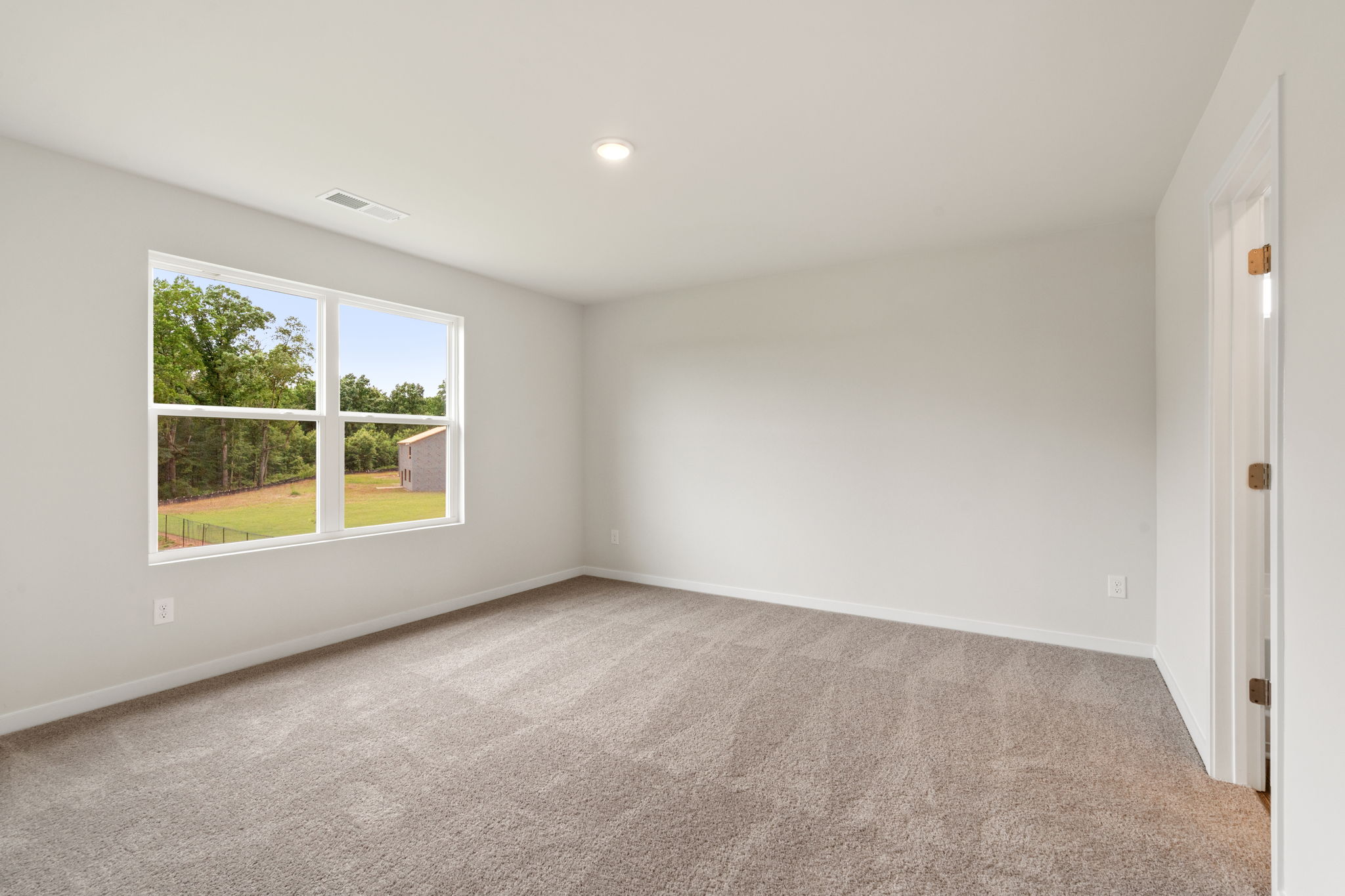 A room with a window and a carpet.