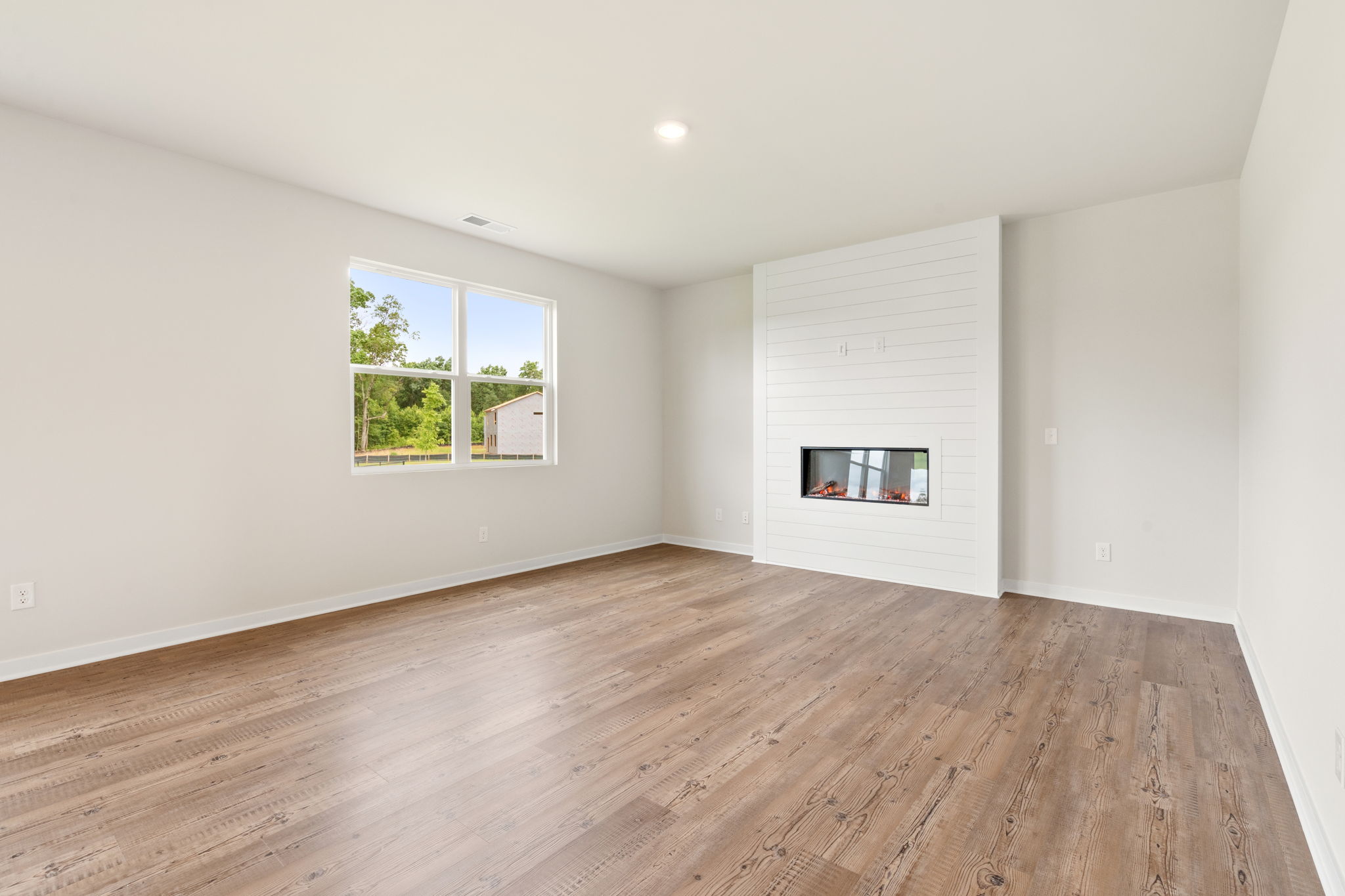 A room with a wood floor and windows.