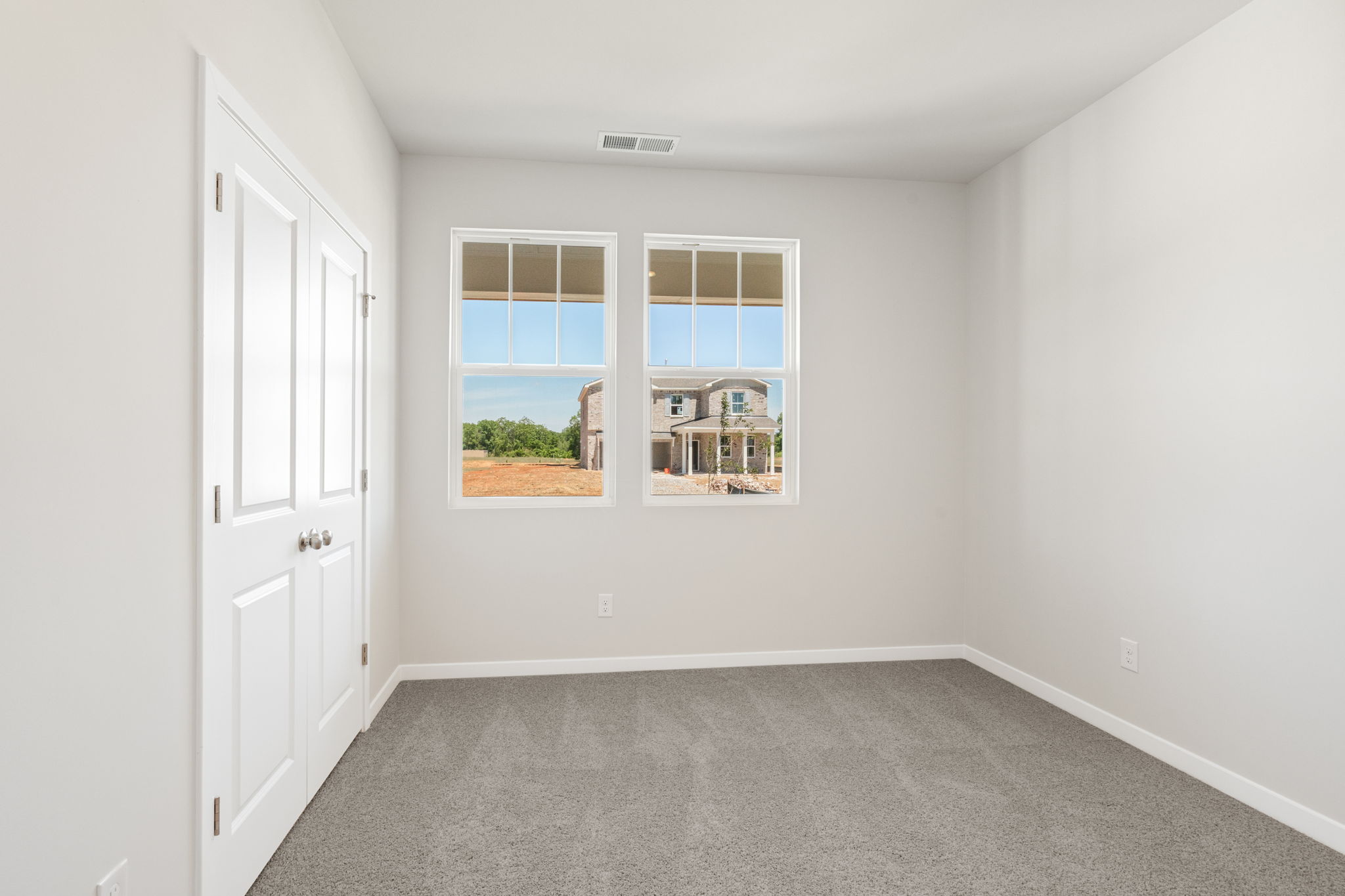 A room with a window and a door with a view of the ocean.