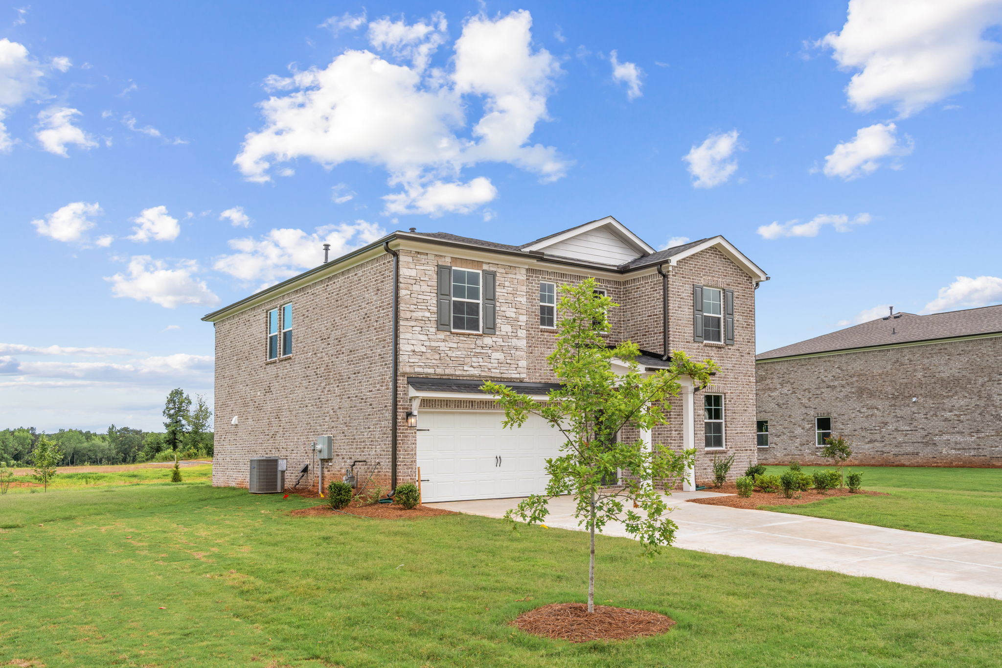 A large brick house with a tree in front of it.