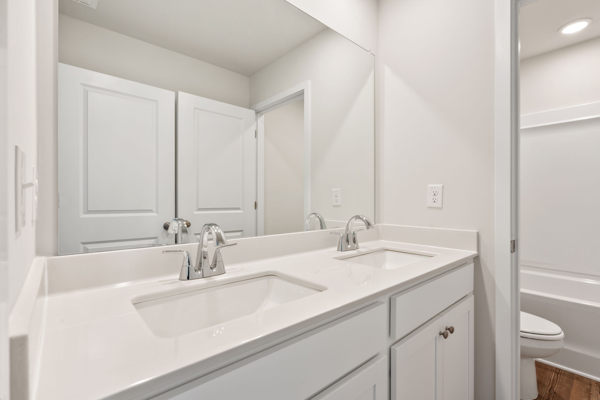 A bathroom with a large mirror.