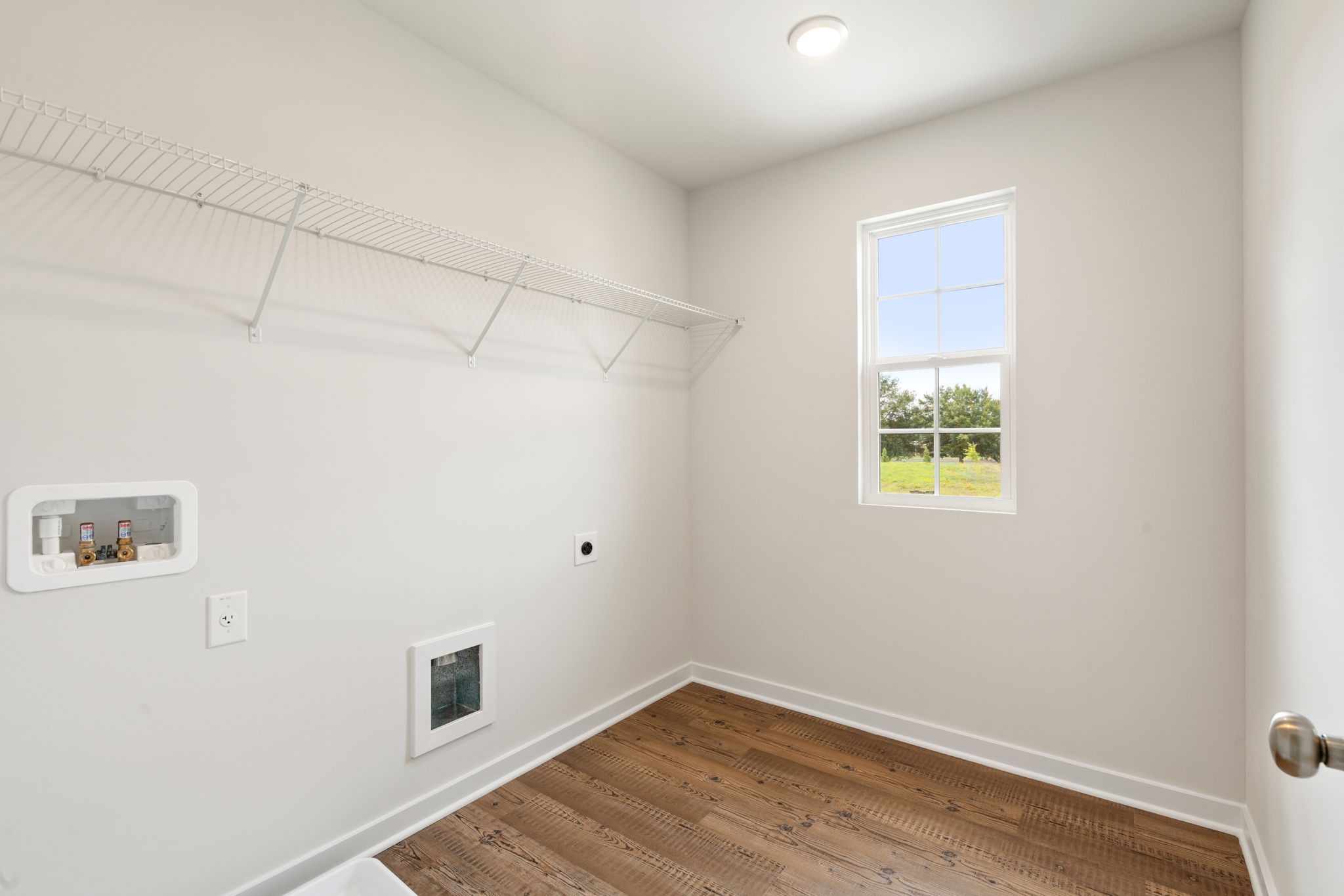 A room with a window and a rug.