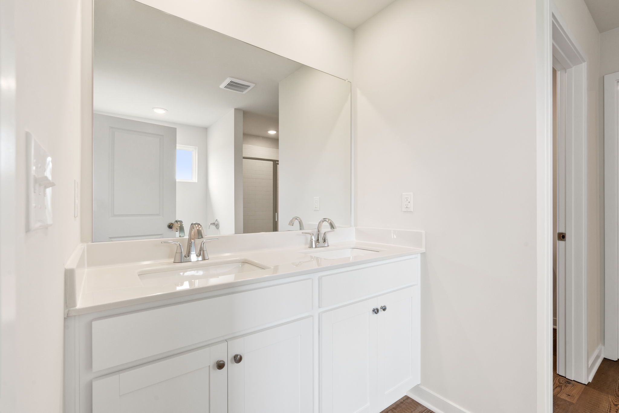 A bathroom with white cabinets.