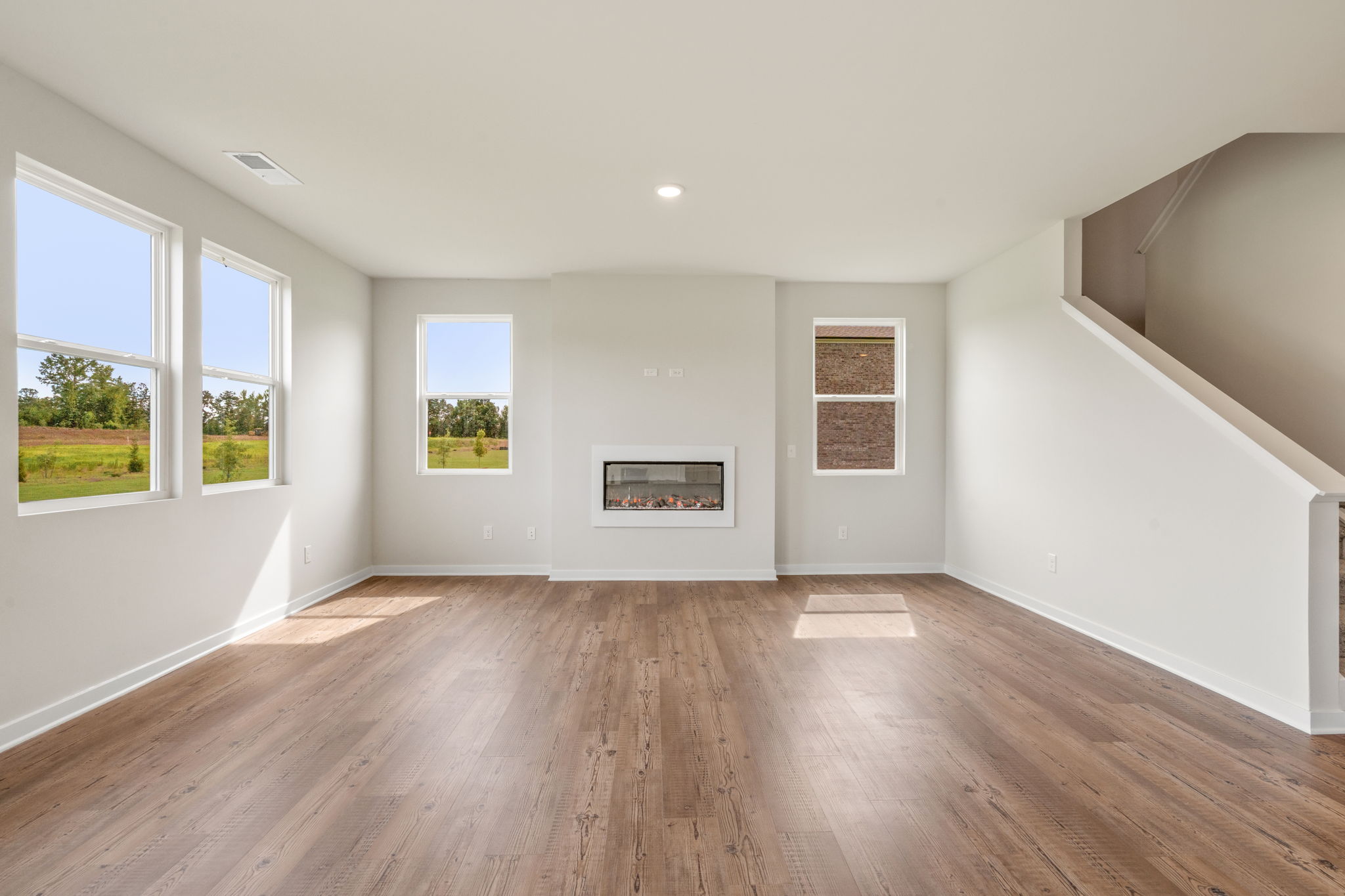 A room with a wood floor and windows.