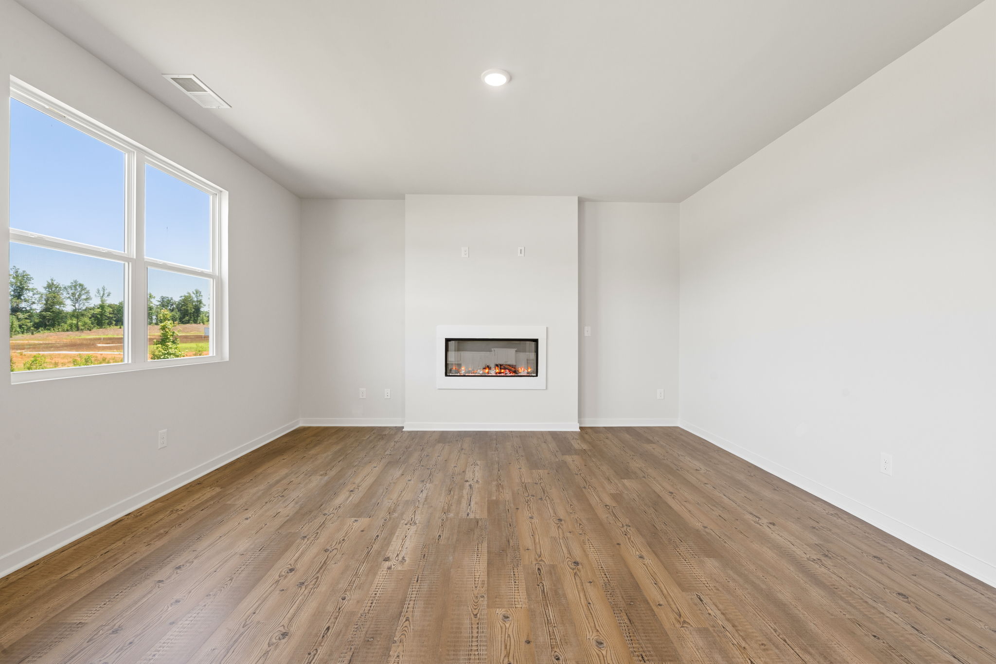 A room with a wood floor and a window with a picture on it.
