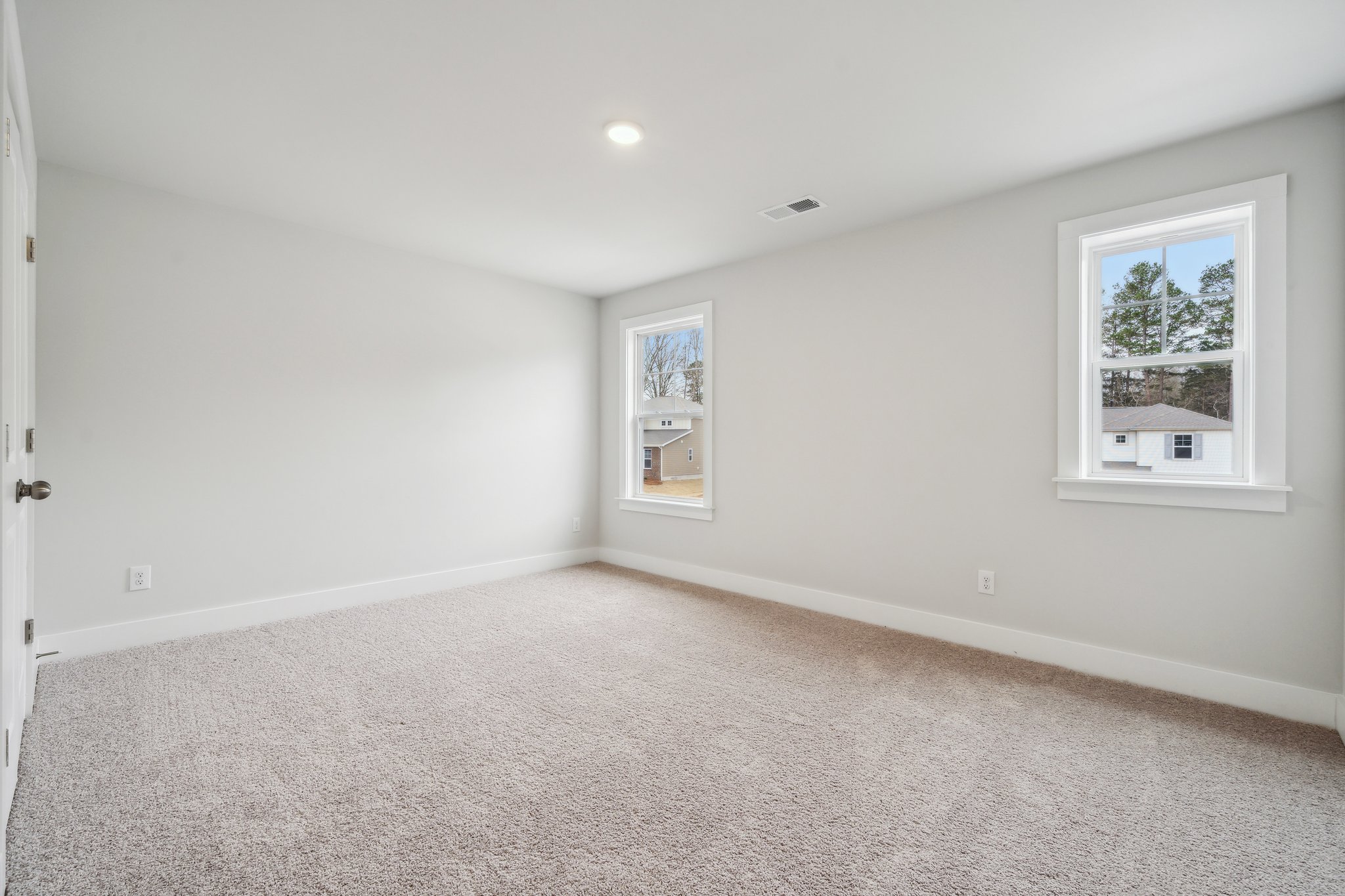A room with a carpet and windows.