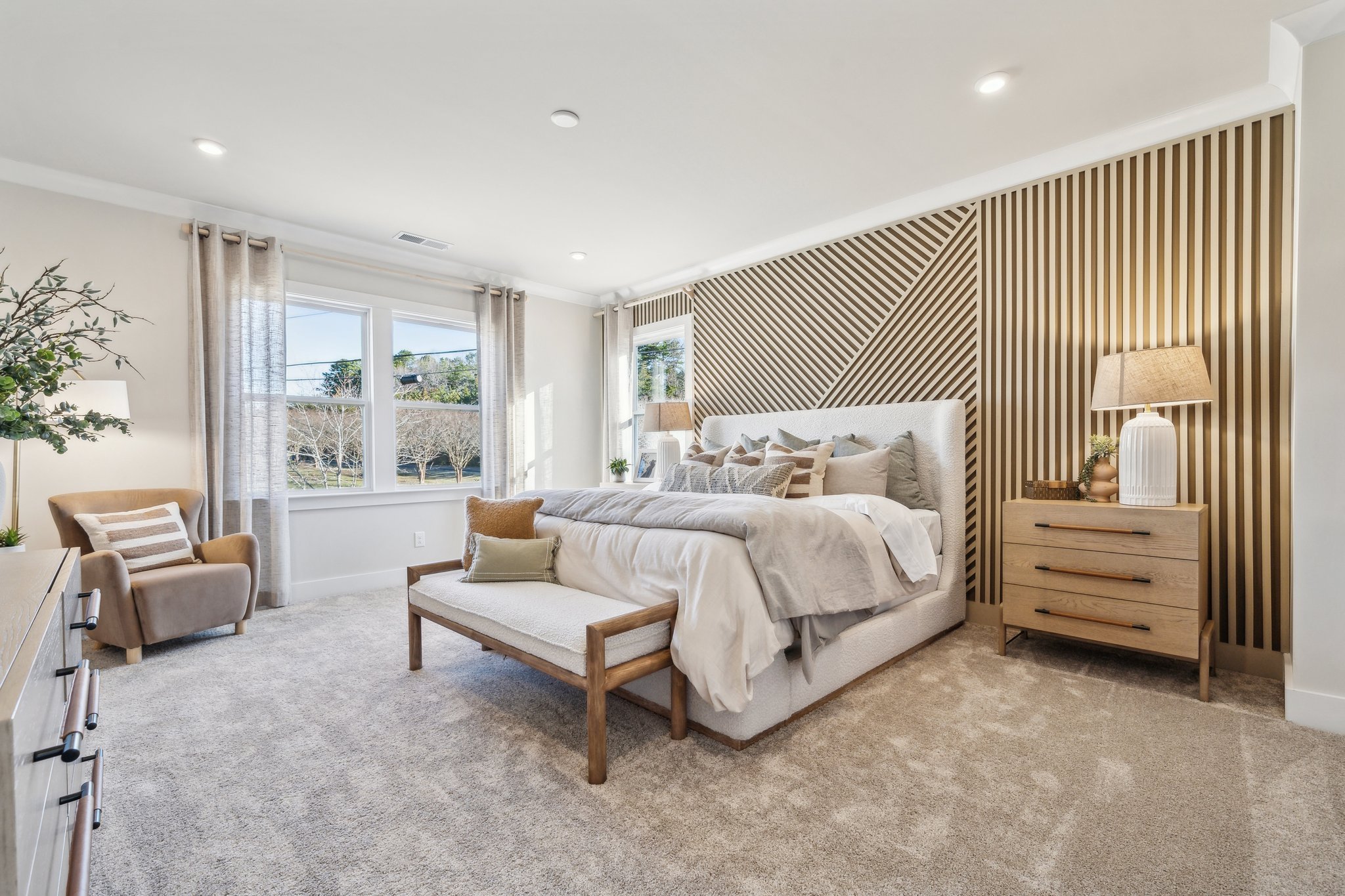 A bedroom with a bed and a bench.