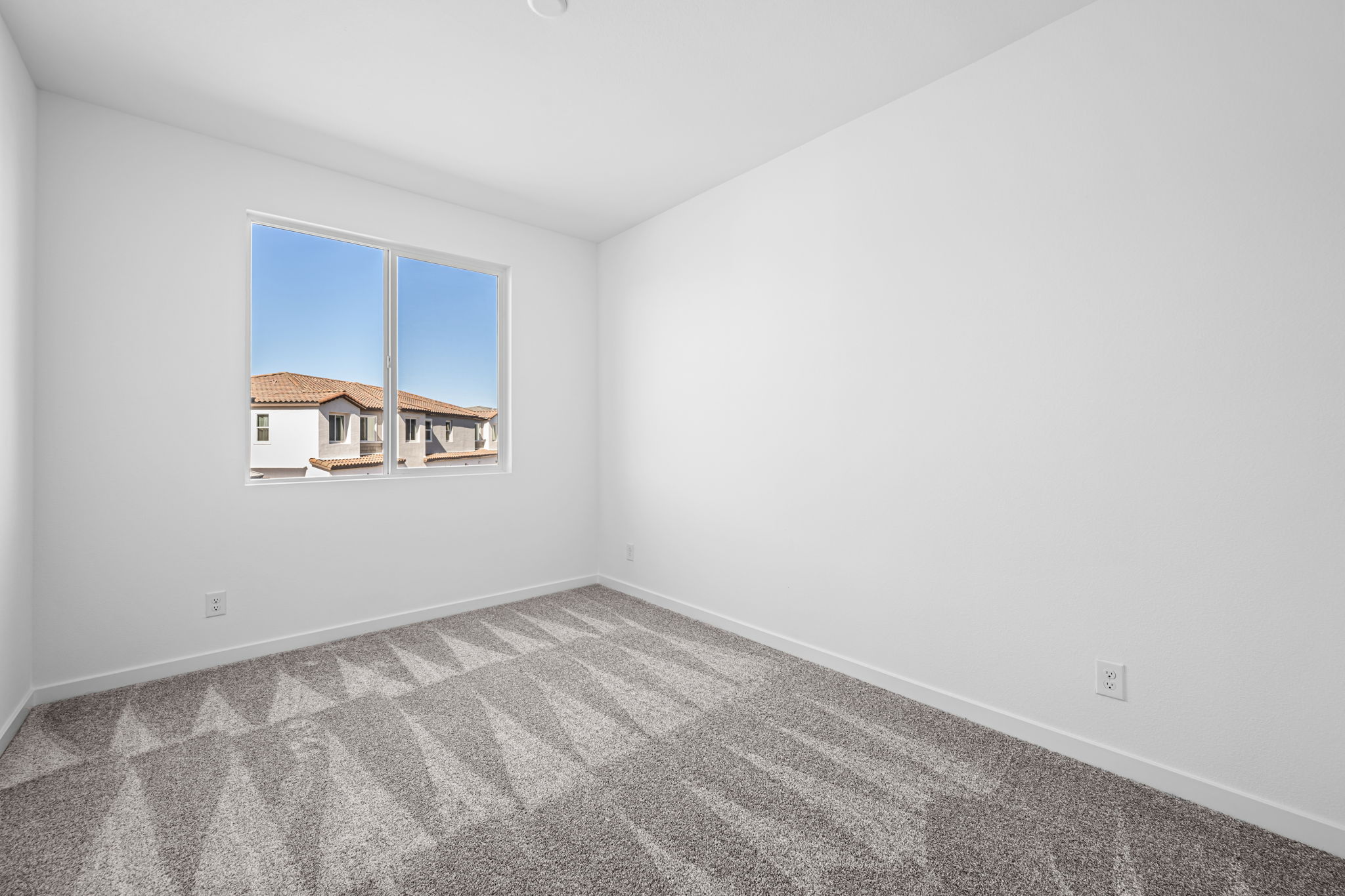 A room with a window and a rug.