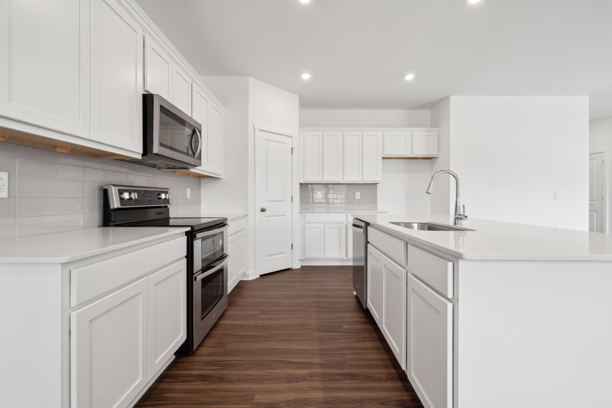 A kitchen with white cabinets.
