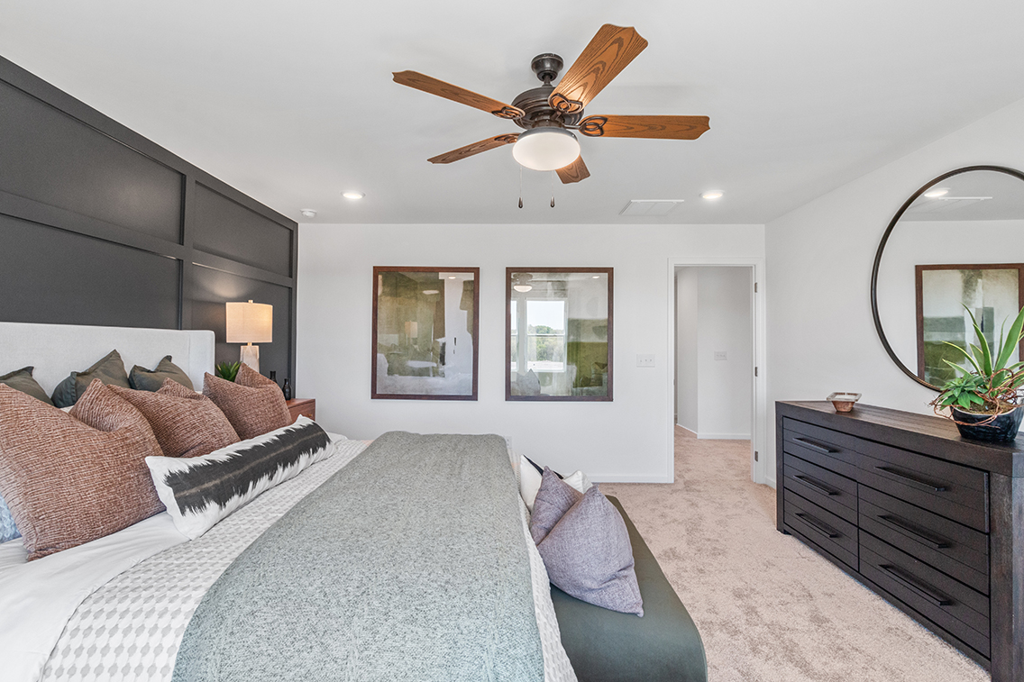 A bedroom with a bed and a fan.