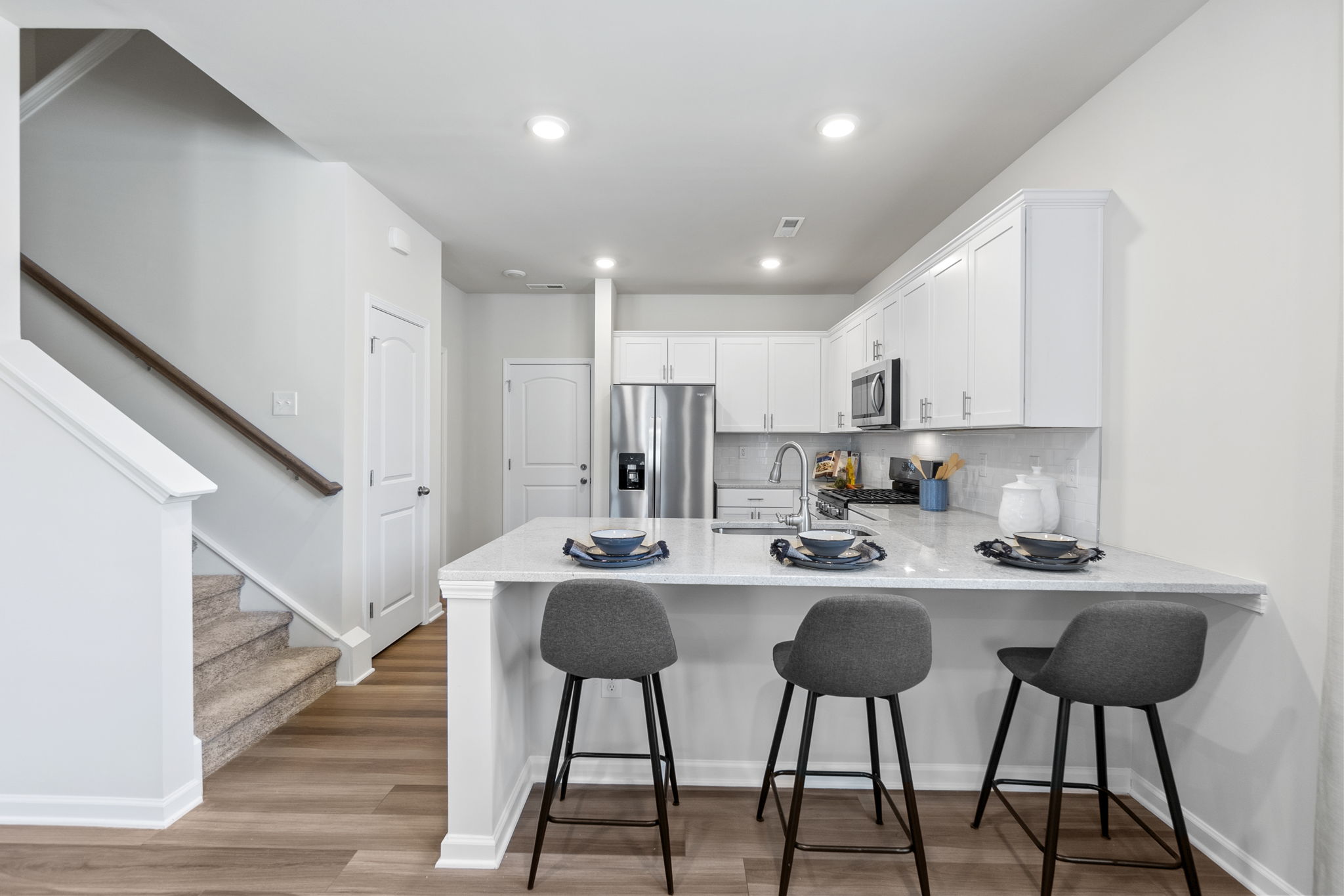 A kitchen with white cabinets.