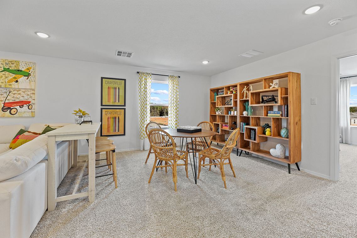 A living room with a table and chairs.