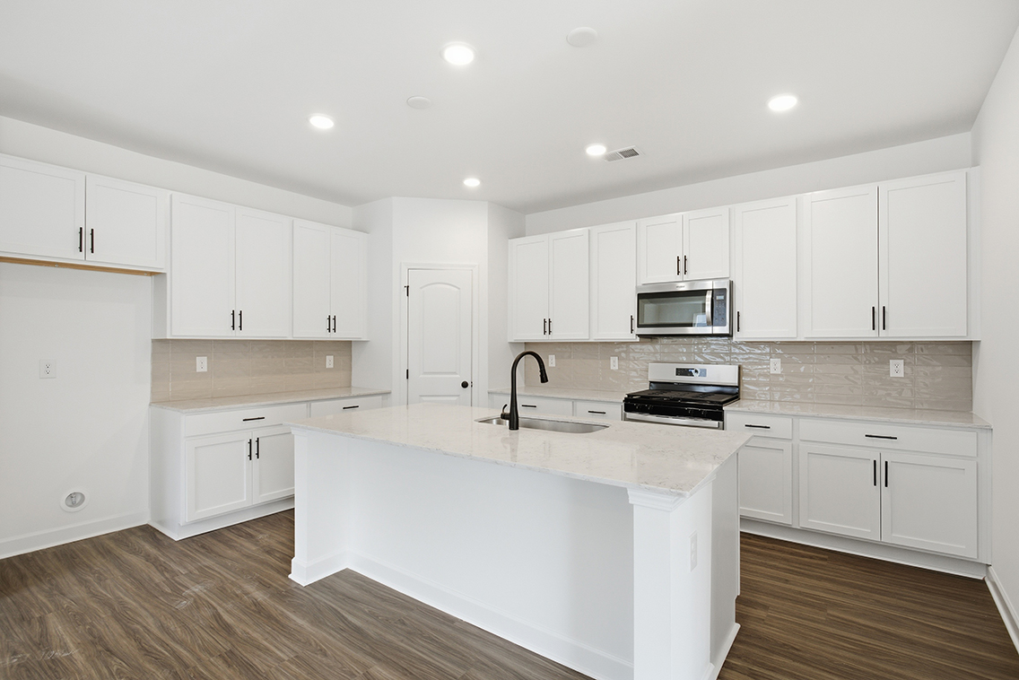 A kitchen with white cabinets.