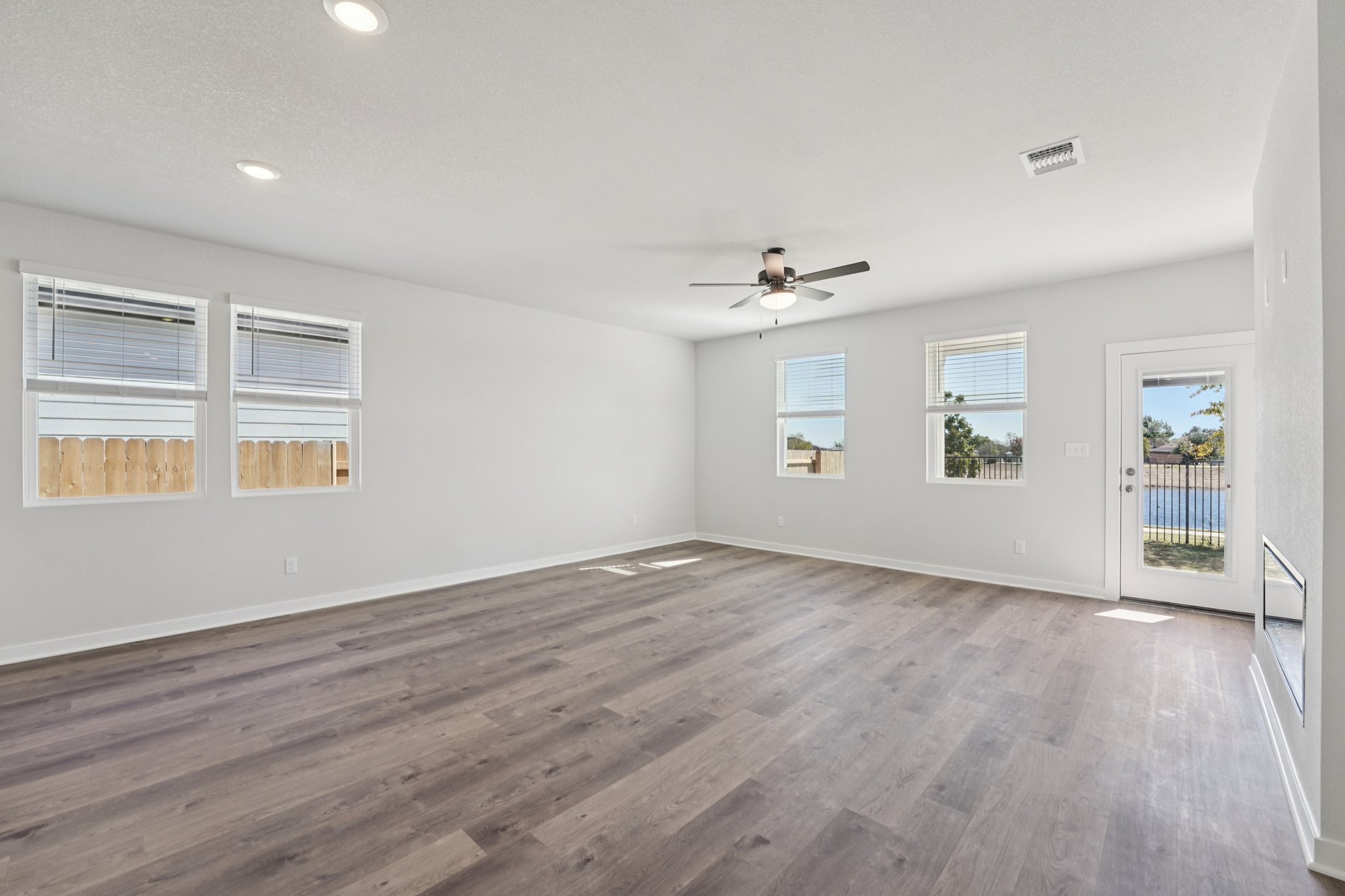 A room with a wood floor and a ceiling fan.