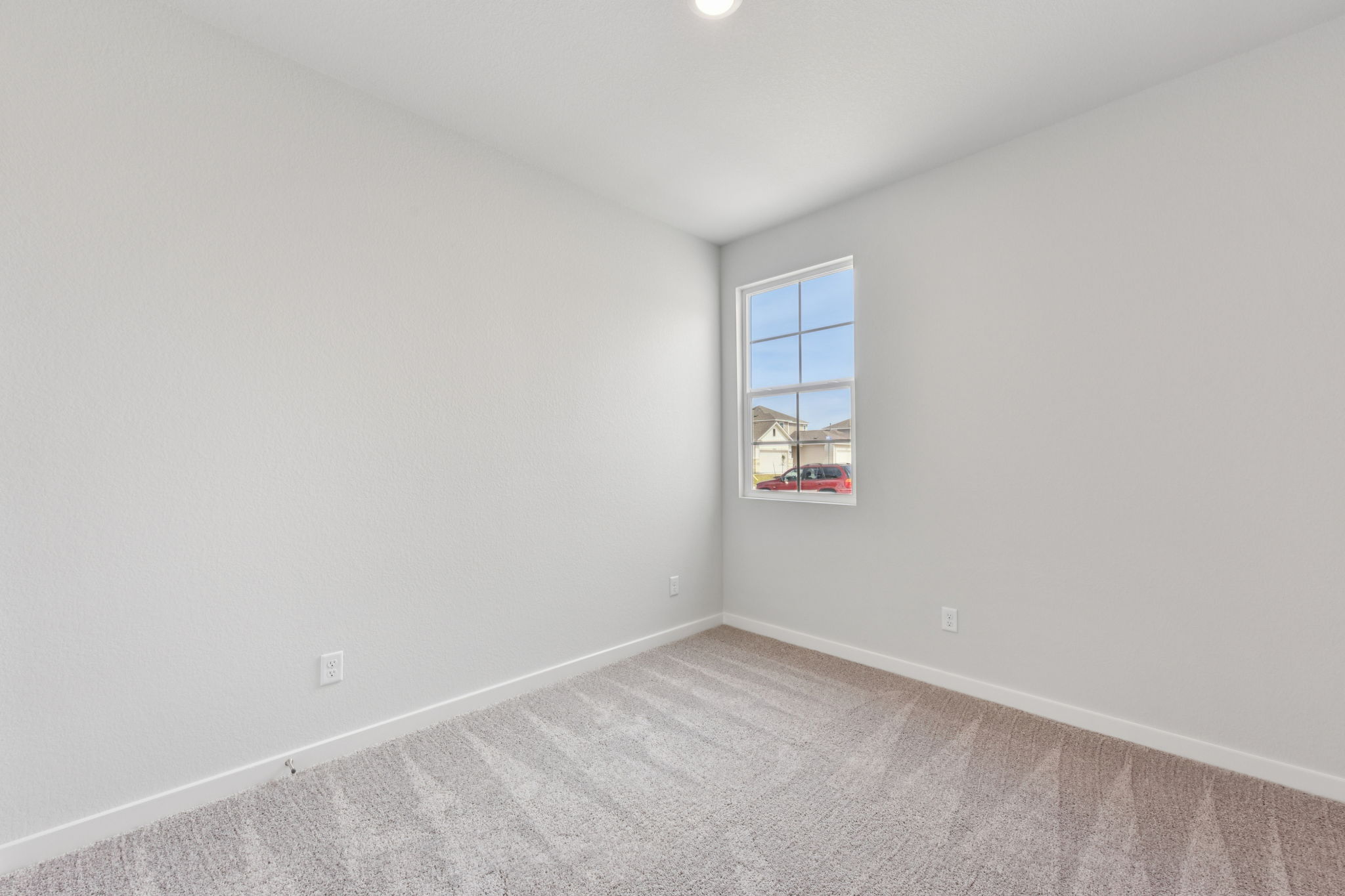 A room with a window and carpet.